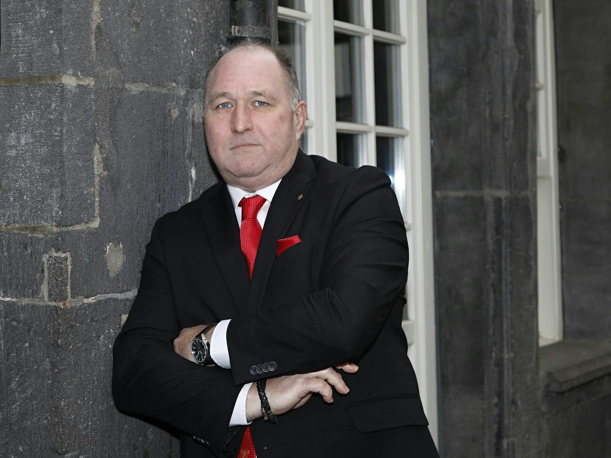 Ralf Schlegelmilch ,Ostermann-Präsident, lehnt mit ernstem Blick an einer Hauswand