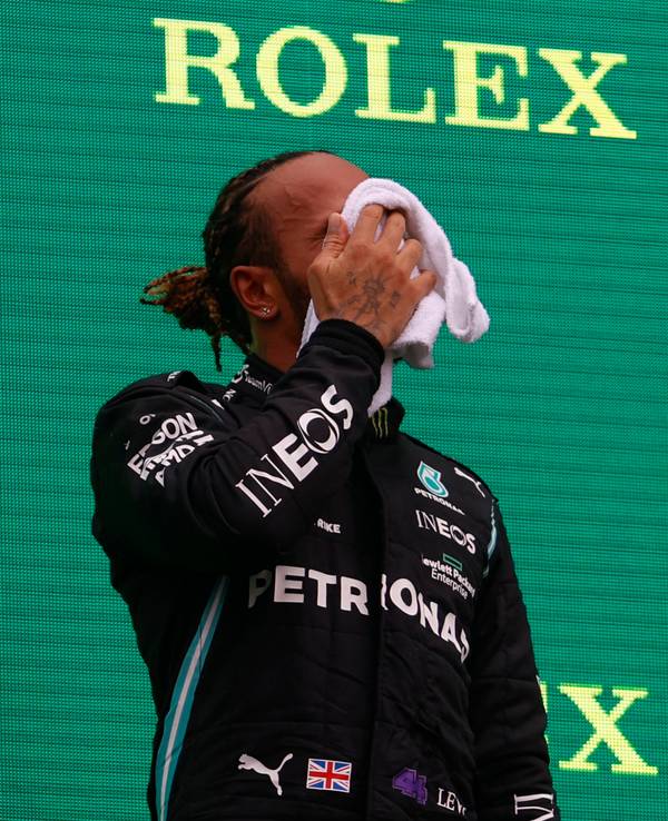 Formel 1: Lewis Hamilton wischt sich das Gesicht trocken auf dem Podium.