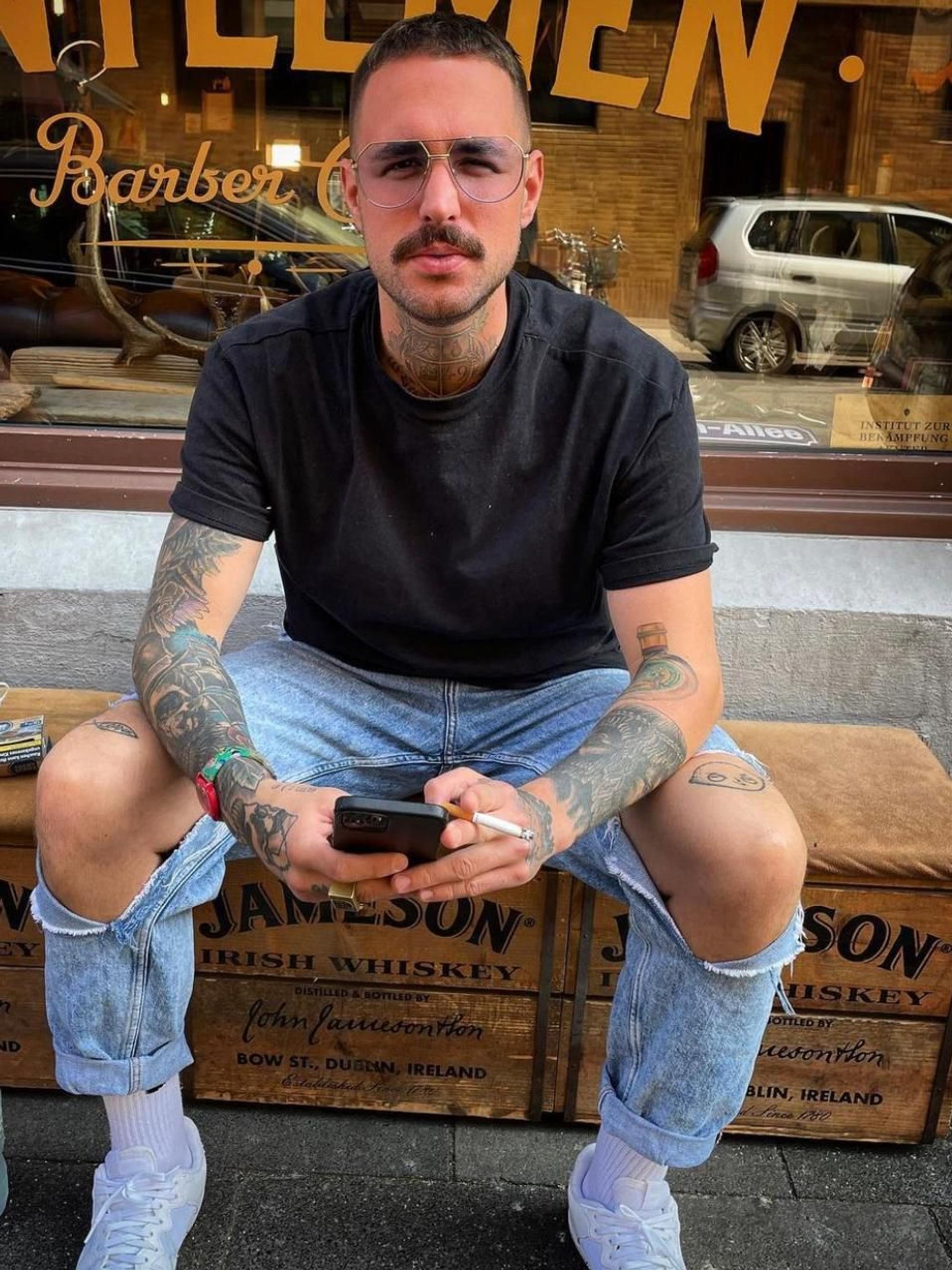 Der Kölner Elmar Heilf sitzt vor dem Gentleman Barber Club.