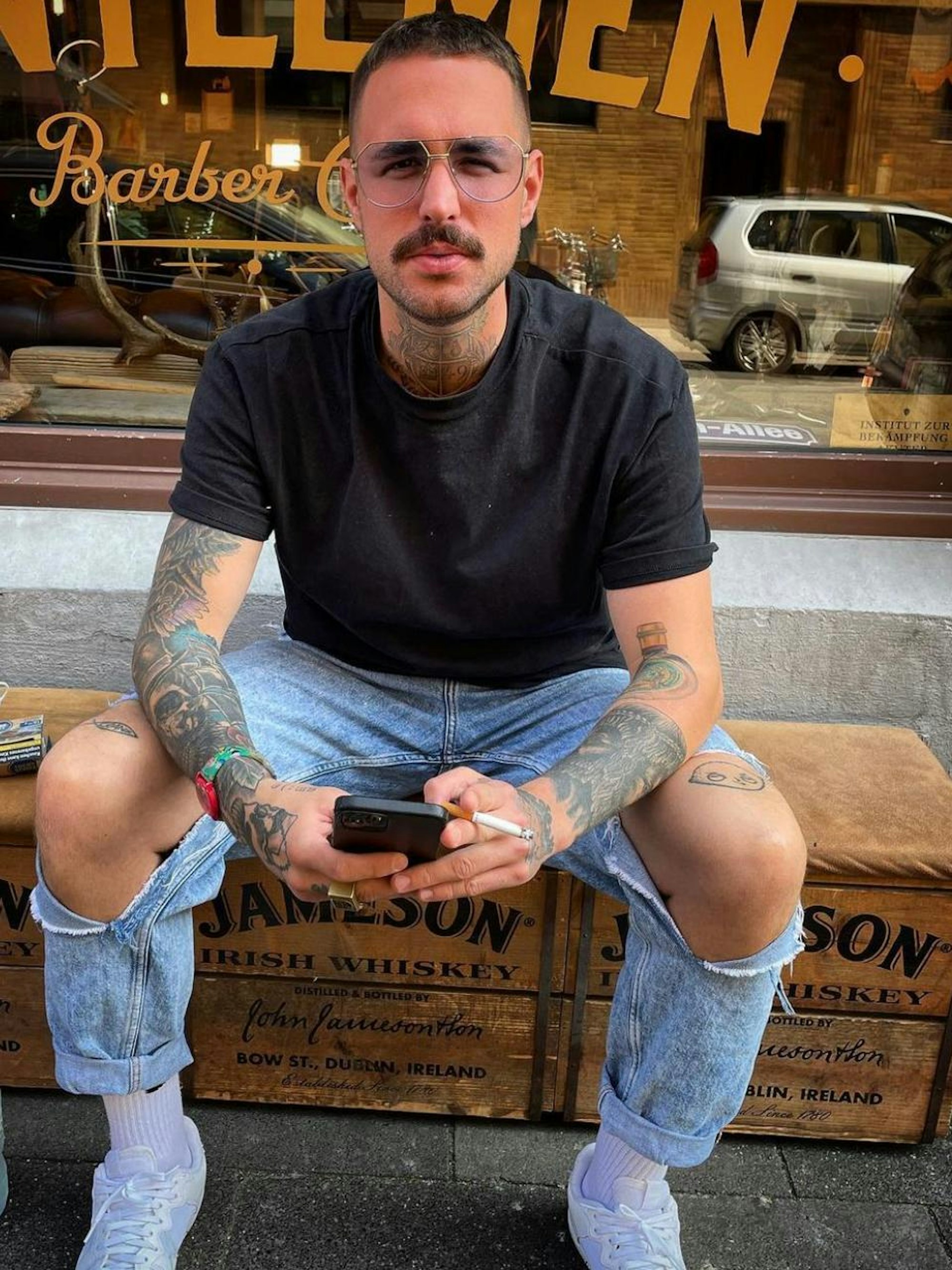 Der Kölner Elmar Heilf sitzt vor dem Gentleman Barber Club.