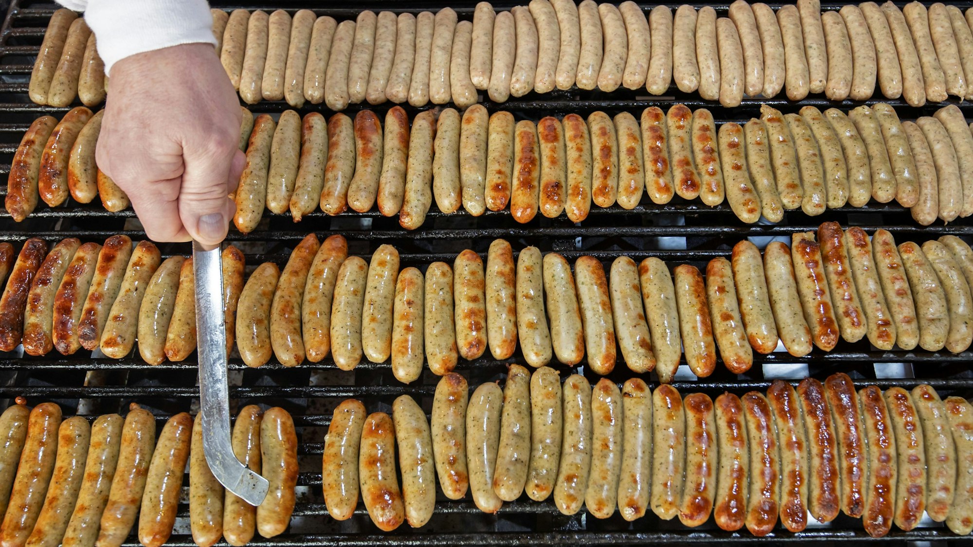Nürnberger Rostbratwürste liegen an einem Stand auf dem Nürnberger Christkindlesmarkt auf einem Grill.