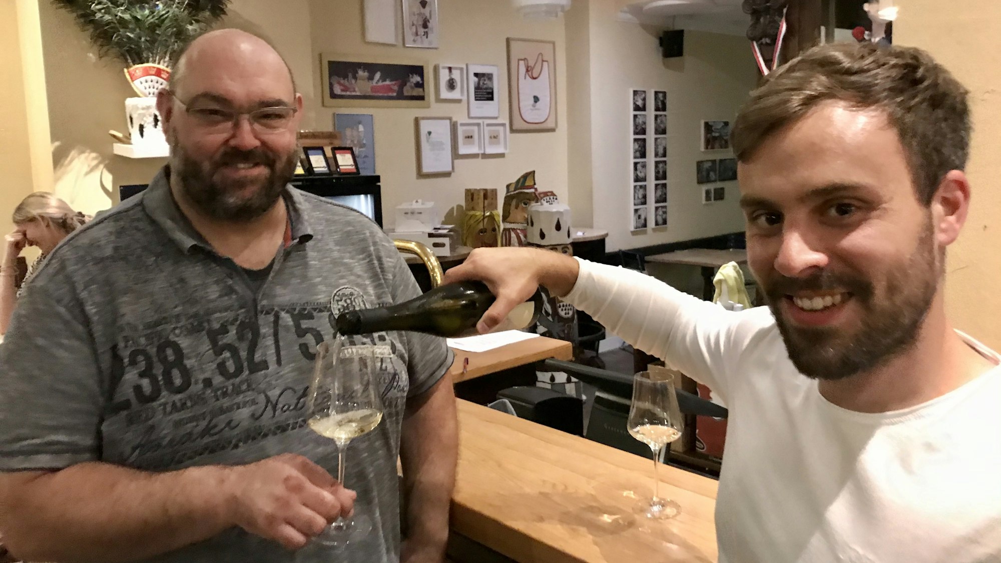 Steffen Burnikel schenkt im Lokal Wirt Thomas Mick Wein ein.