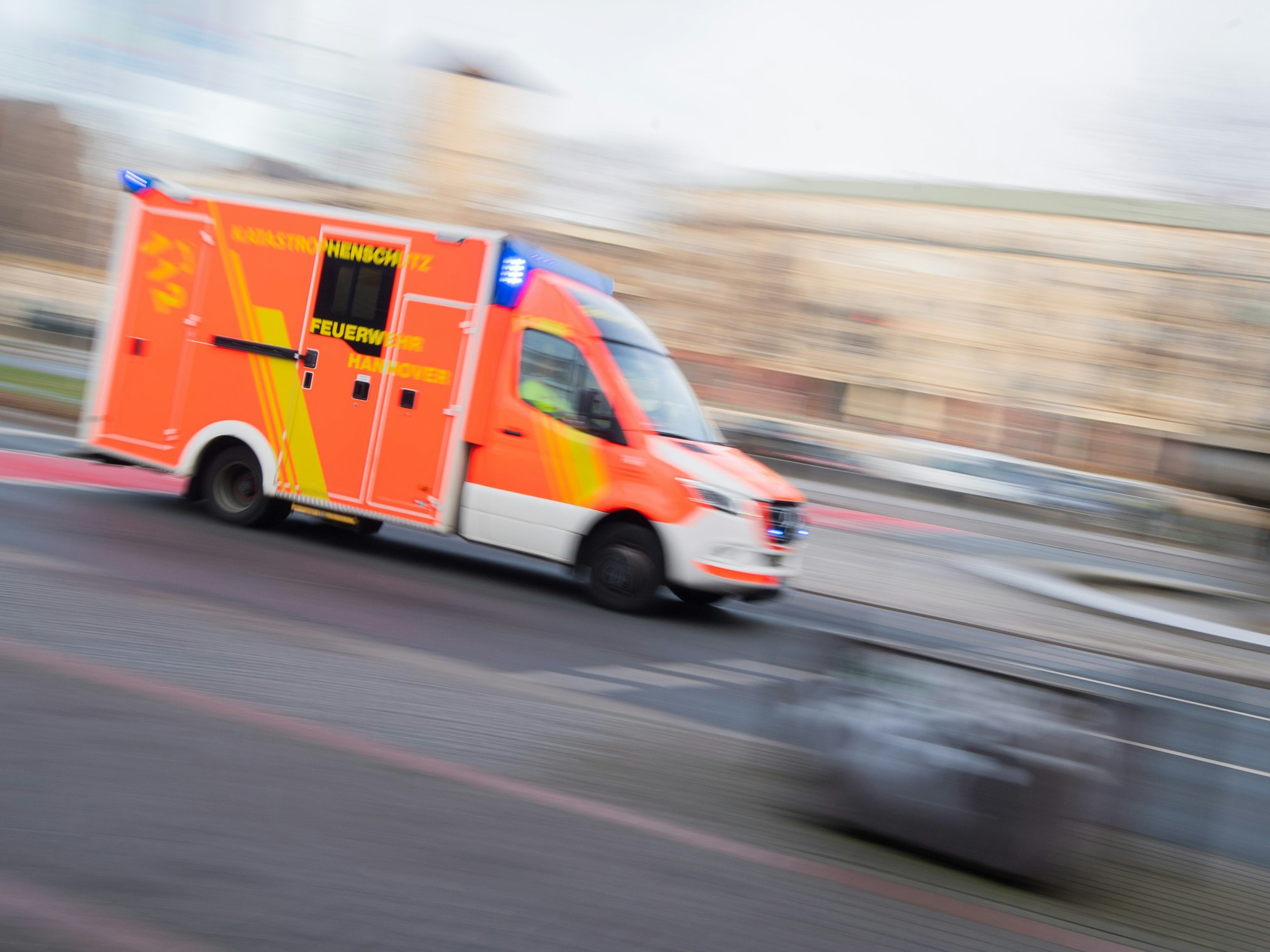 Ein Rettungswagen der Feuerwehr Hannover fährt mit Blaulicht durch die Innenstadt.