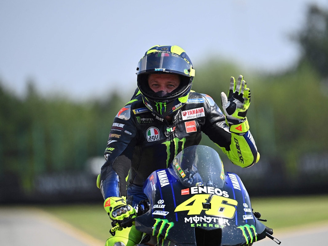 Valentino Rossi winkt nach einem MotoGP-Rennen auf seinem Motorrad.