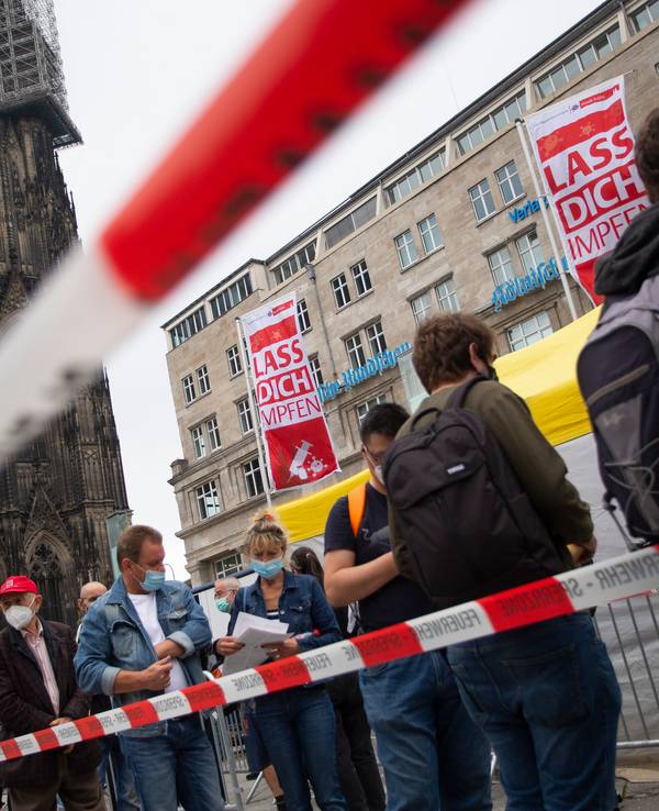 Menschen stehen Schlange bei einer Corona-Impfaktion der Stadt Köln vor dem Hauptbahnhof und Kölner Dom.
