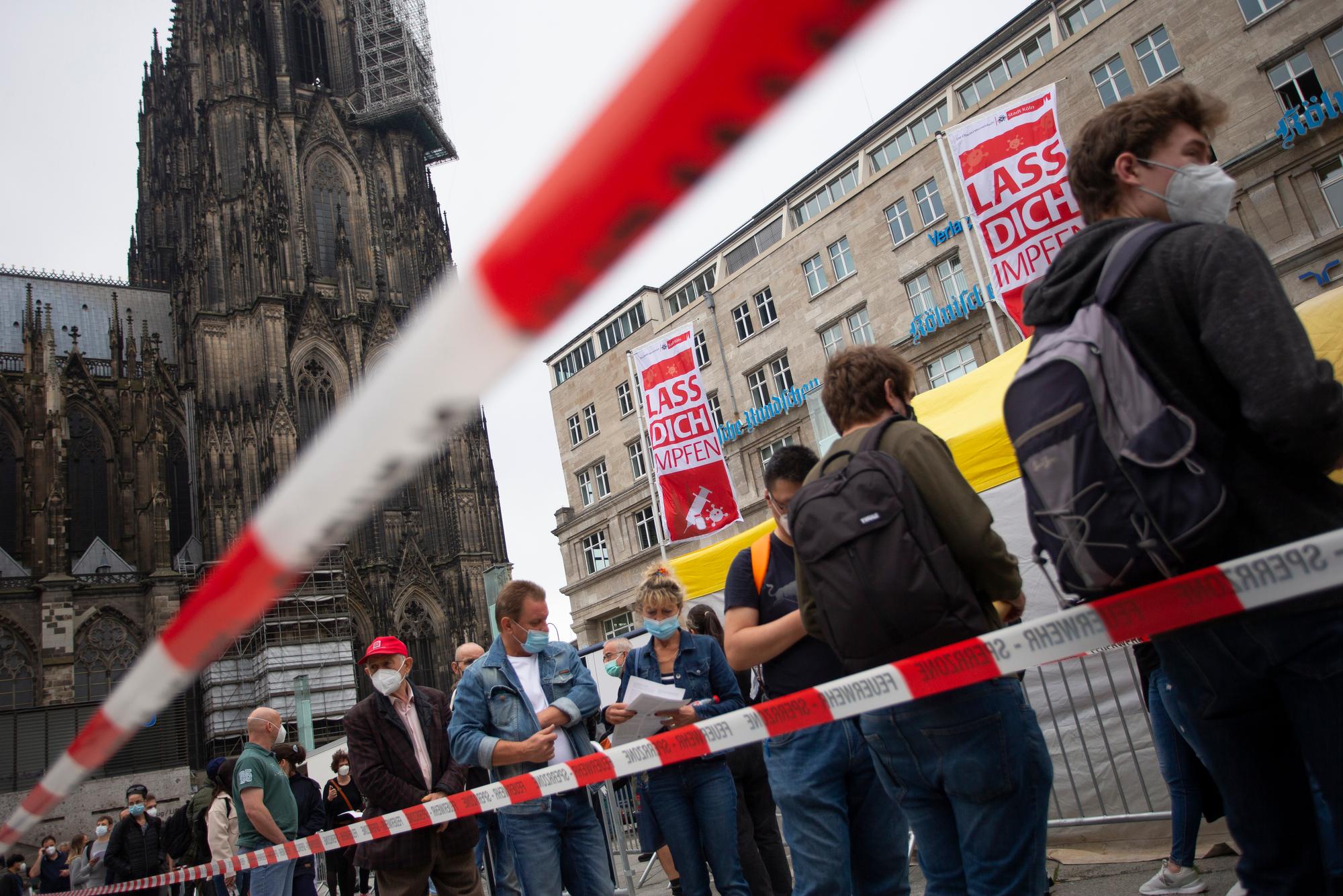 Menschen stehen Schlange bei einer Corona-Impfaktion der Stadt Köln vor dem Hauptbahnhof und Kölner Dom.