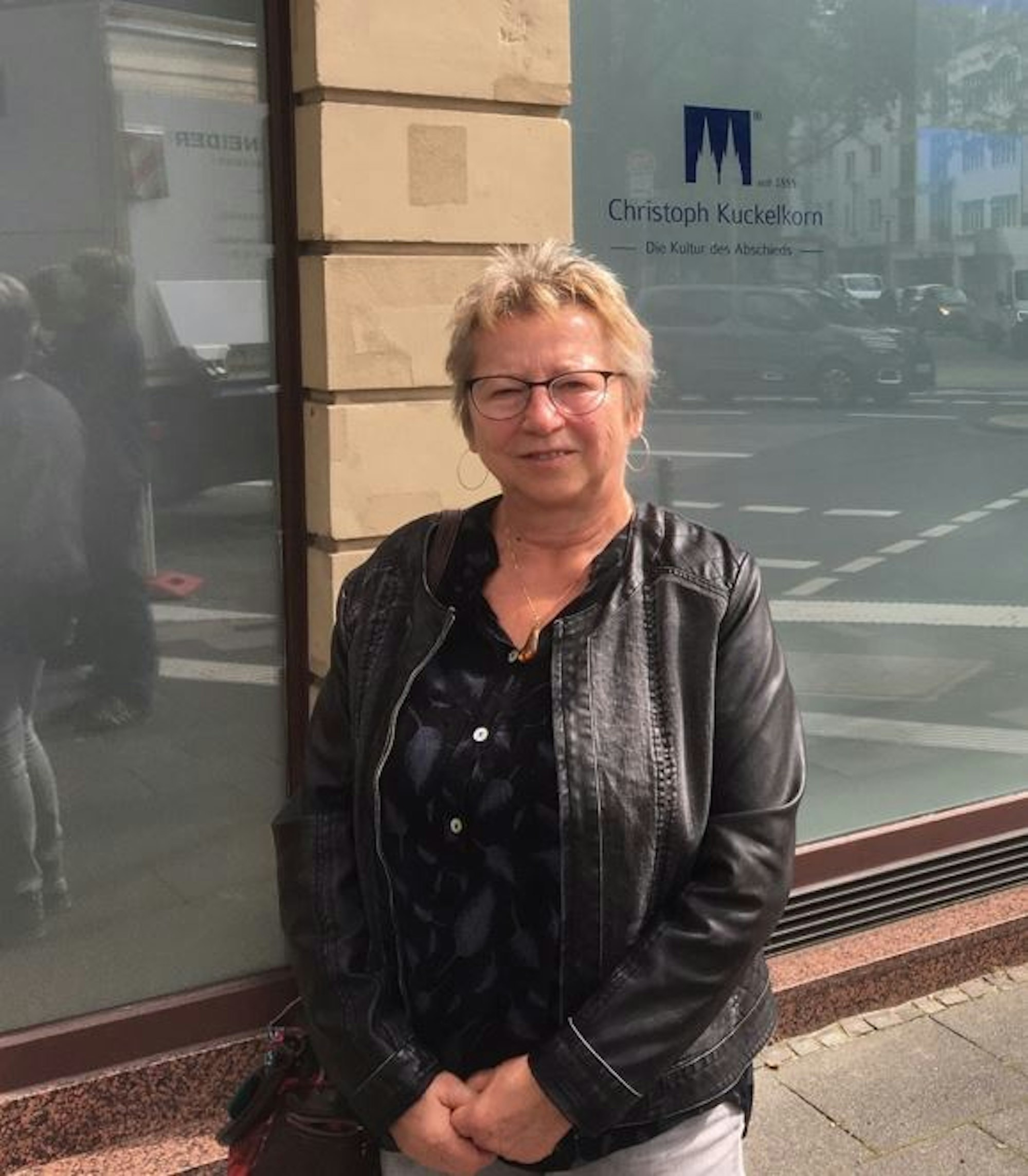 Elke Budach steht vor dem Bestattungshaus Kuckelkorn.