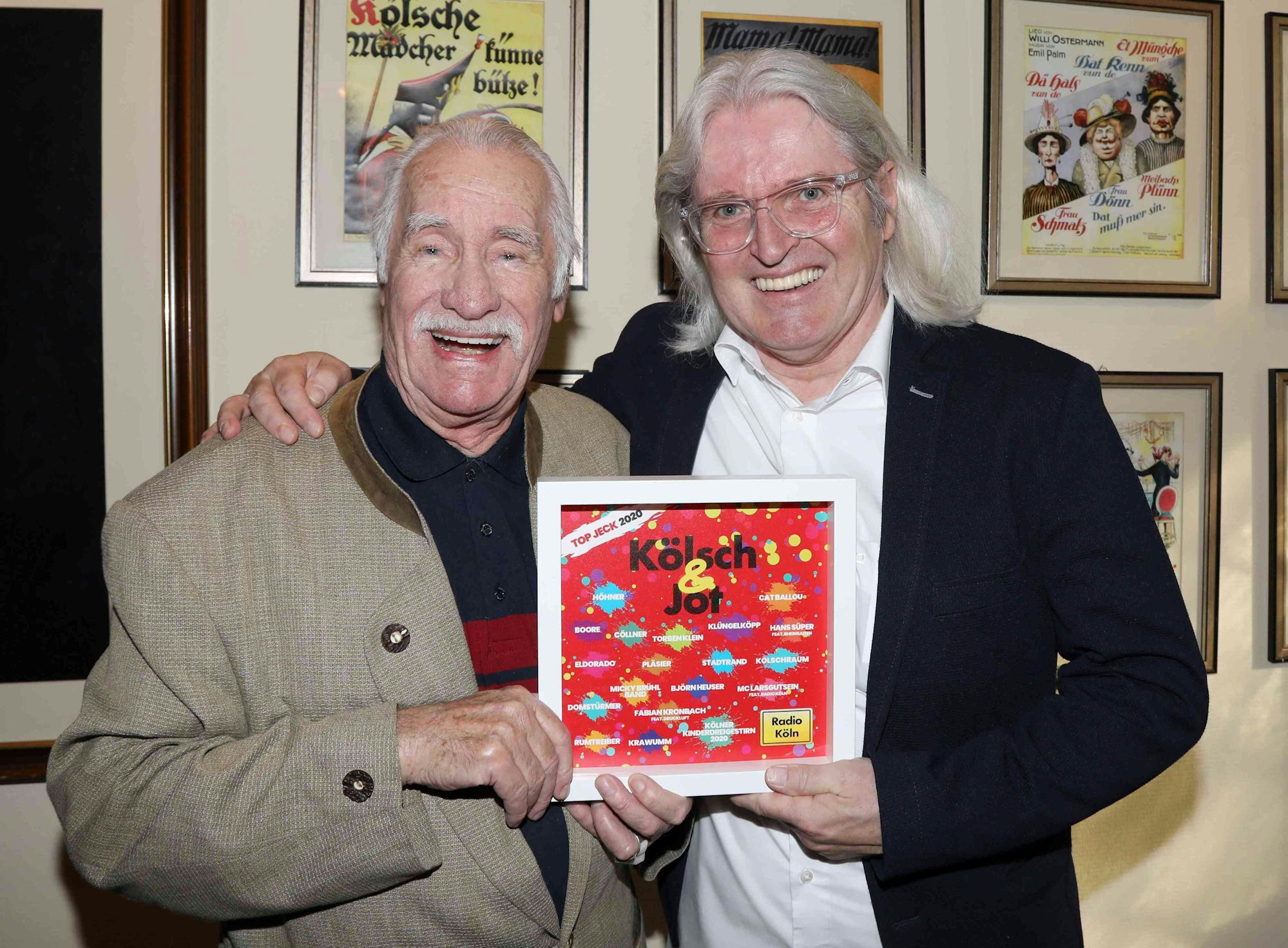 Hans Süper steht mit Jürgen Hoppe im Haus Unkelbach und präsentiert die CD Kölsch un Jot.