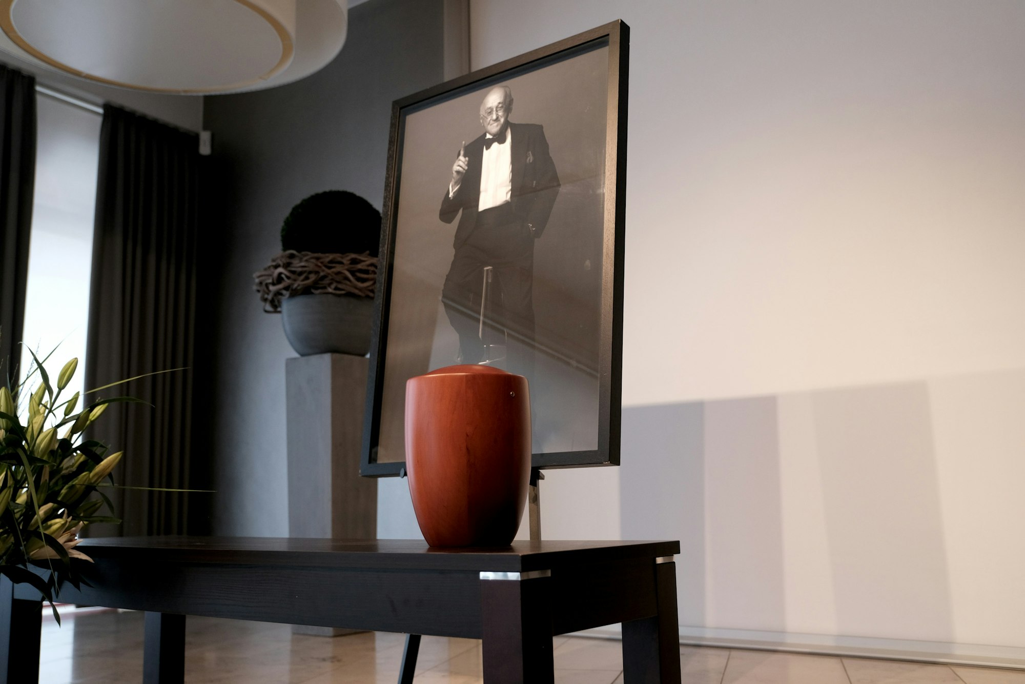 Die Urne von Alfred Biolek, dahinter ein Foto von ihm, steht in einem Raum.