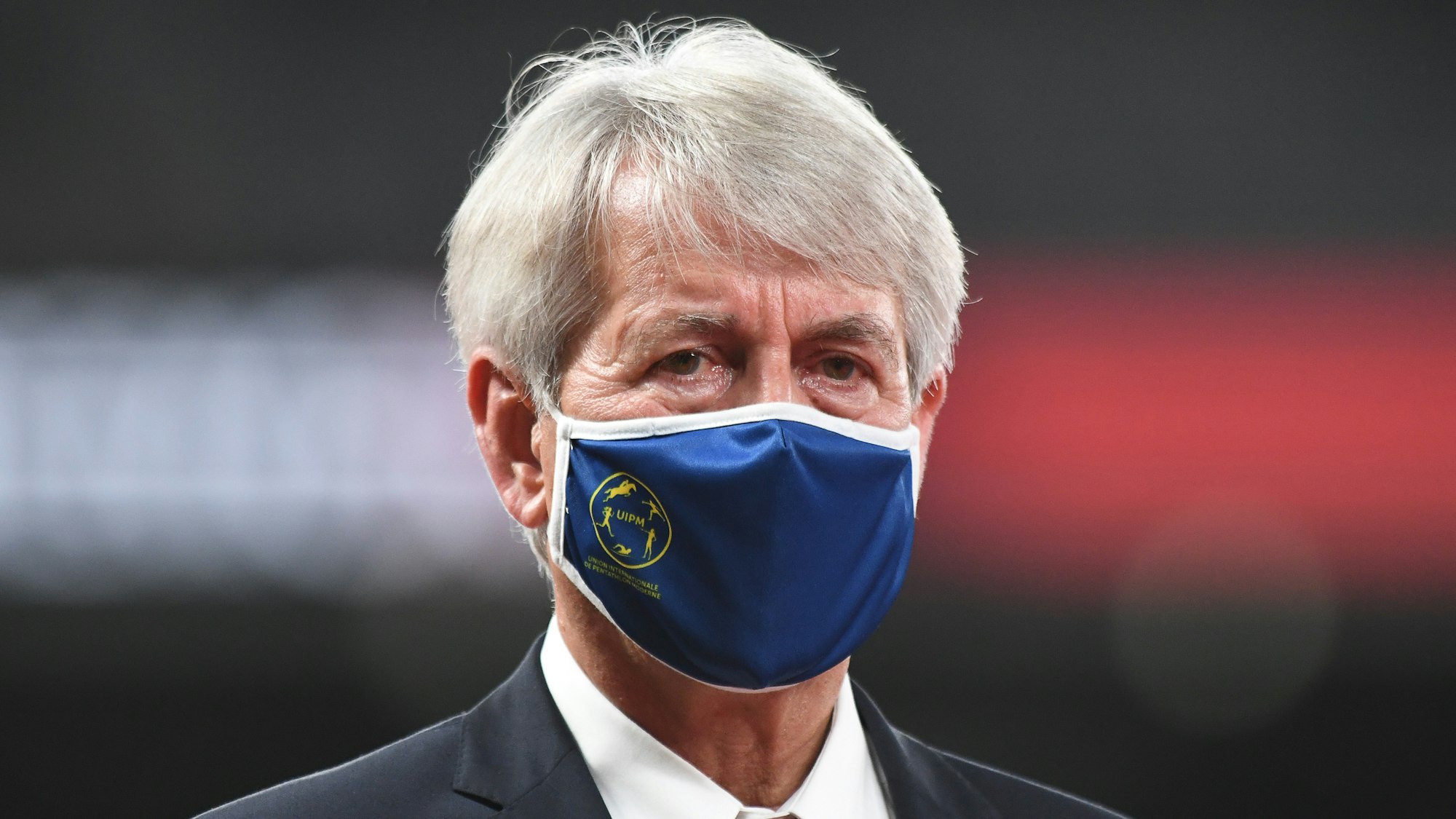 Klaus Schormann verfolgt mit Maske den Modernen Fünfkampf bei Olympia.