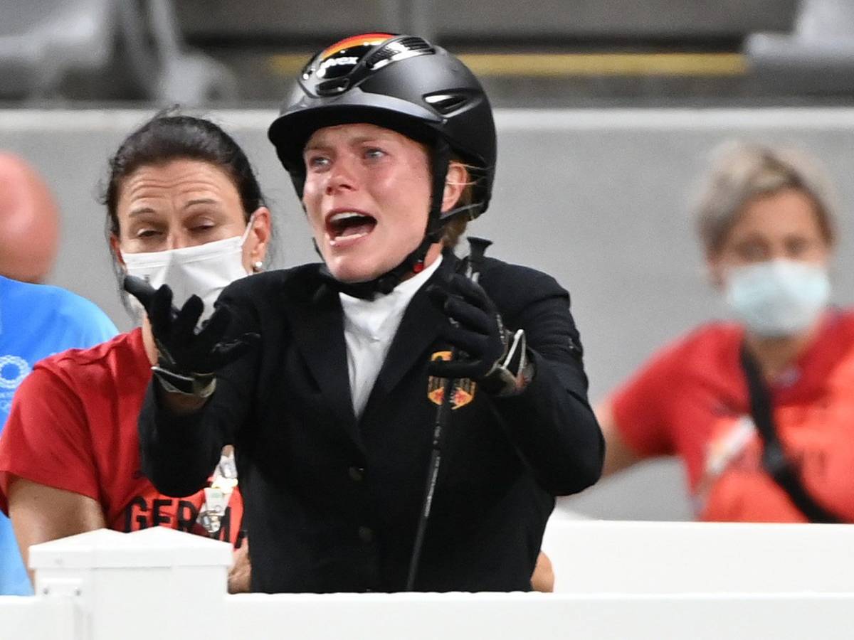 Annika Schleu hebt beim Springreit-Wettbewerb des Olympischen Fünfkampfes in Tokio klagend die Arme.