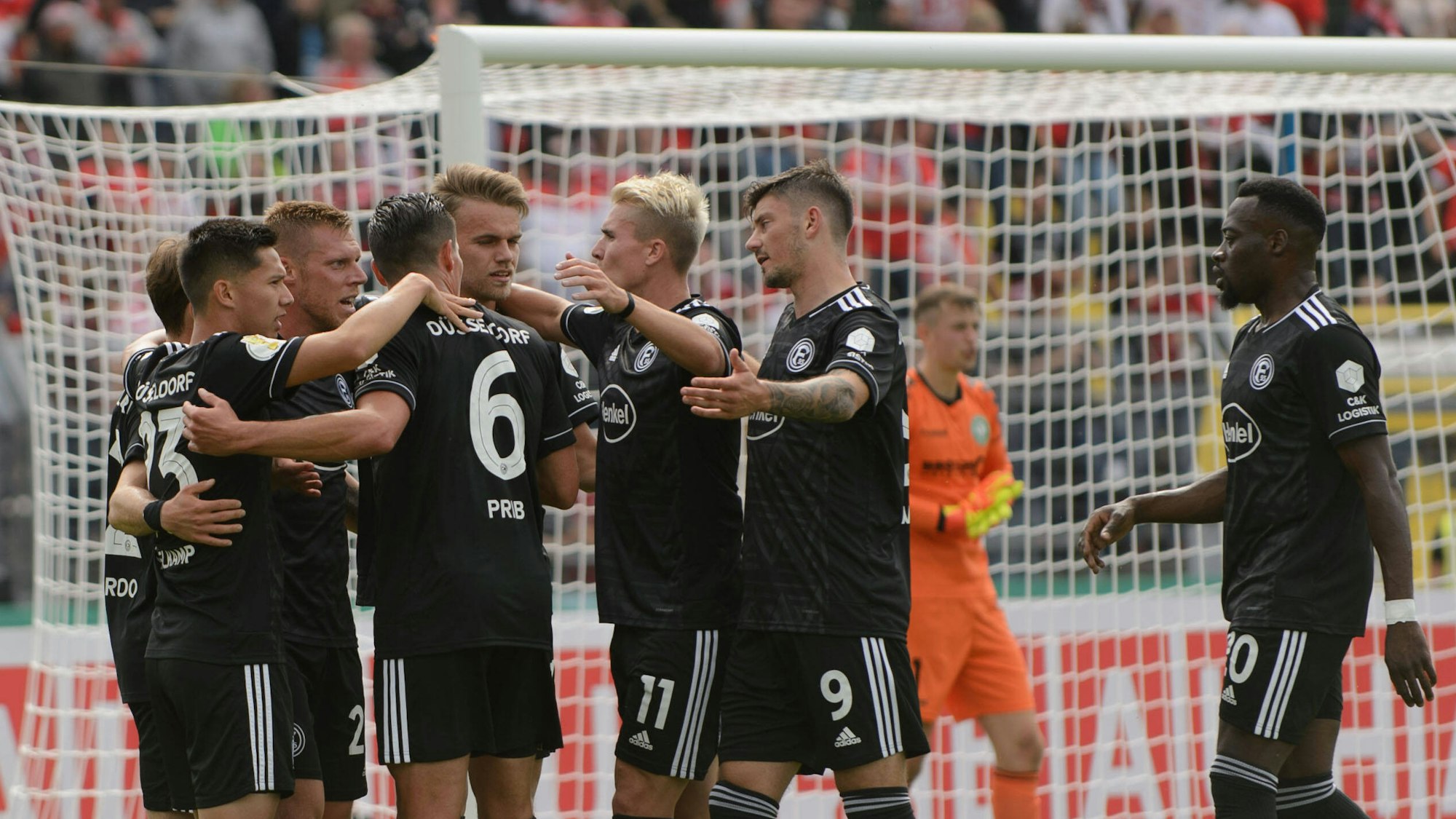 Die Spieler von Fortuna Düsseldorf bejubeln im DFB-Pokal in der Spielertraube ein Tor von Rouwen Hennings.
