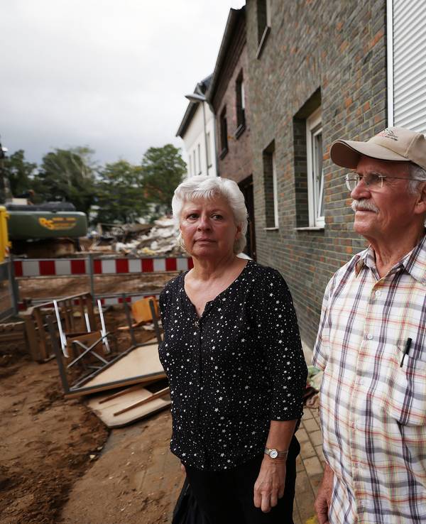 Maria Dunkel, Anwohnerin in Erftstadt-Blessem, spricht vor ihrem Haus mit dem Nachbarn Günter Groten. In Erftstadt tat sich in der Nacht zum 15. Juli die Erde auf und verschlang mehrere Häuser.