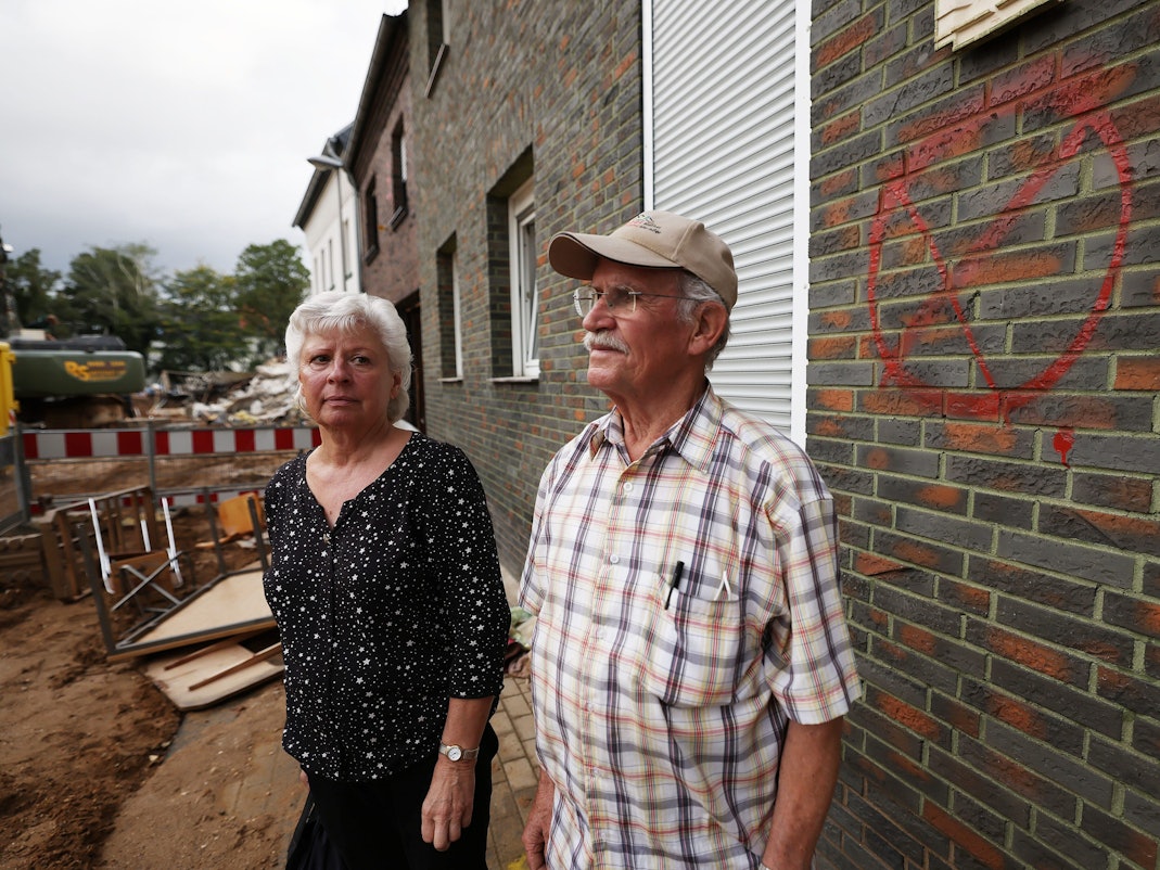 Maria Dunkel, Anwohnerin in Erftstadt-Blessem, spricht vor ihrem Haus mit dem Nachbarn Günter Groten. In Erftstadt tat sich in der Nacht zum 15. Juli die Erde auf und verschlang mehrere Häuser.