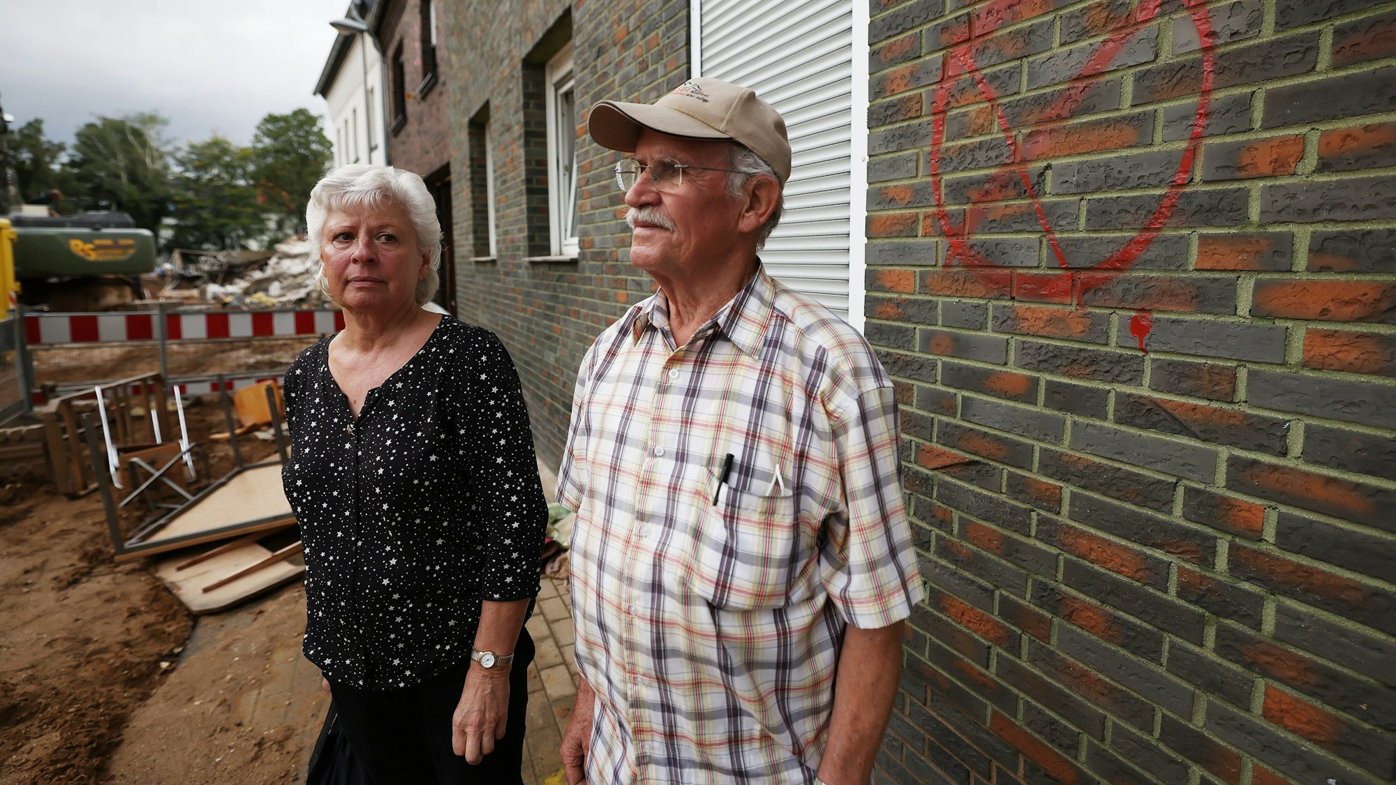 Maria Dunkel, Anwohnerin in Erftstadt-Blessem, spricht vor ihrem Haus mit dem Nachbarn Günter Groten. In Erftstadt tat sich in der Nacht zum 15. Juli die Erde auf und verschlang mehrere Häuser.