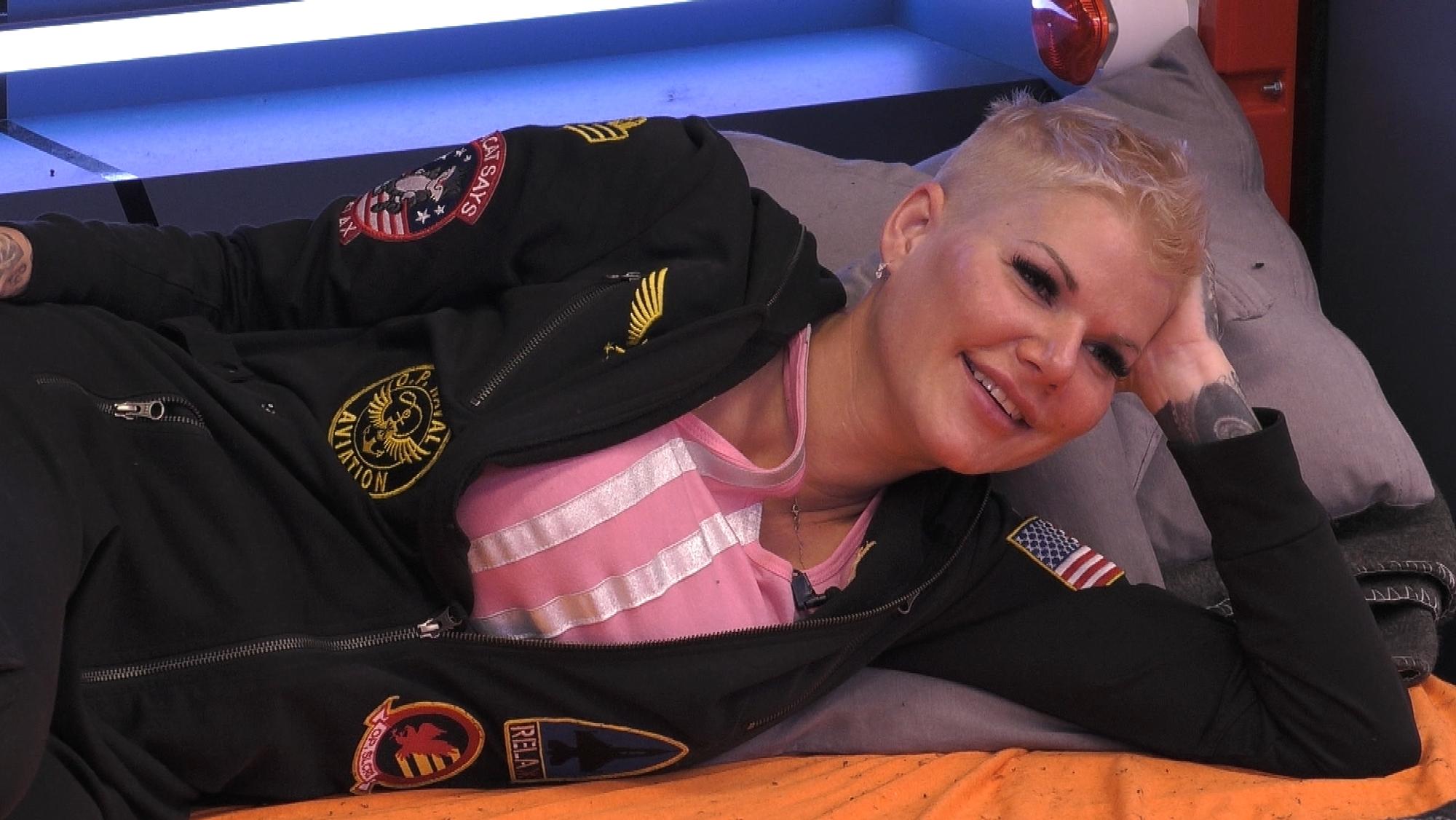 Melanie Müller stützt sich auf ihren Arm während sie mit den Kandidaten bei „Promi Big Brother” über ihr Privatleben spricht.