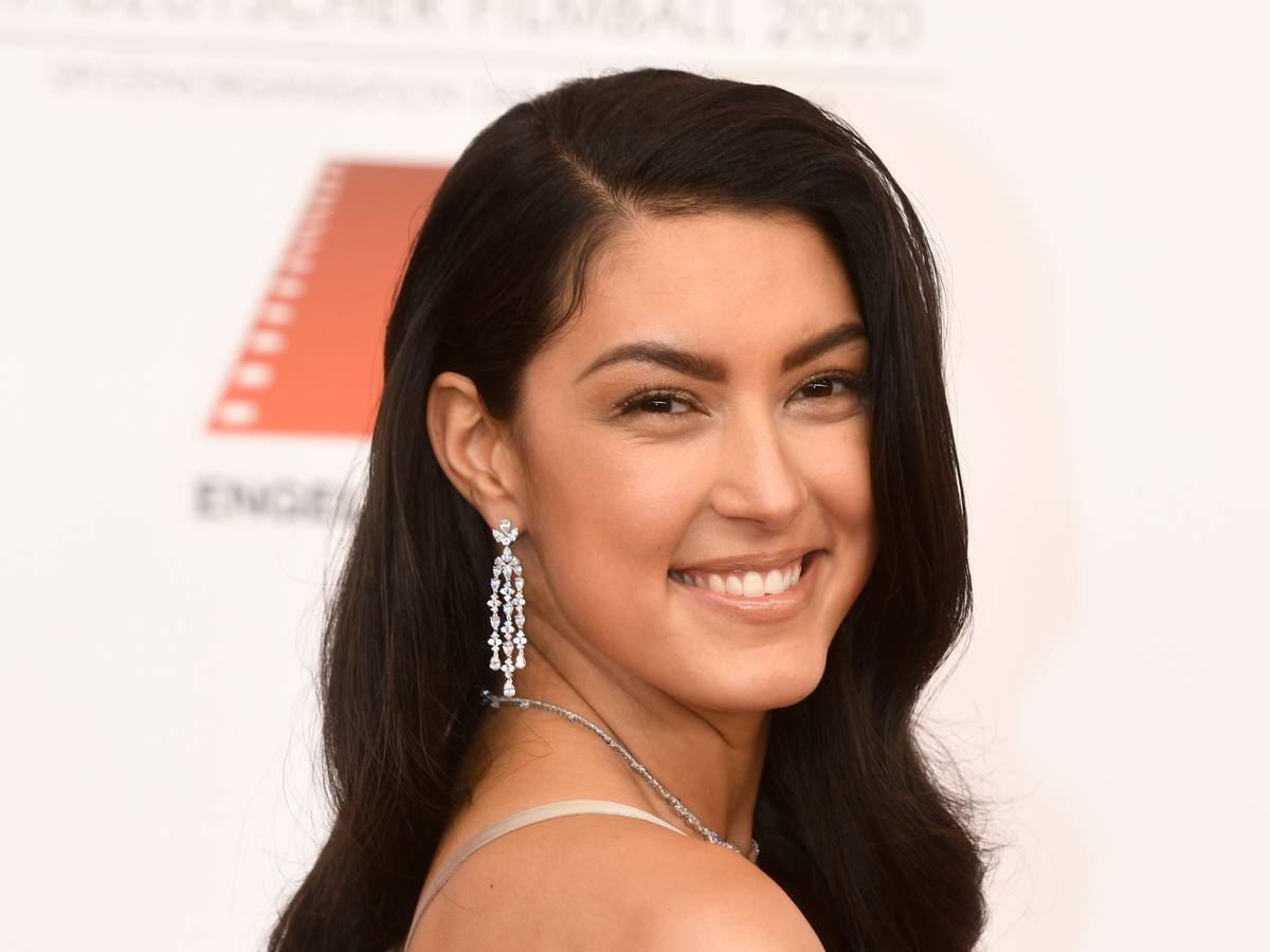 Rebecca Mir, Model, posiert beim 47. Deutschen Filmball ins Hotel Bayerischer Hof mit offenen Haaren in einem beigefarbenen Kleid.