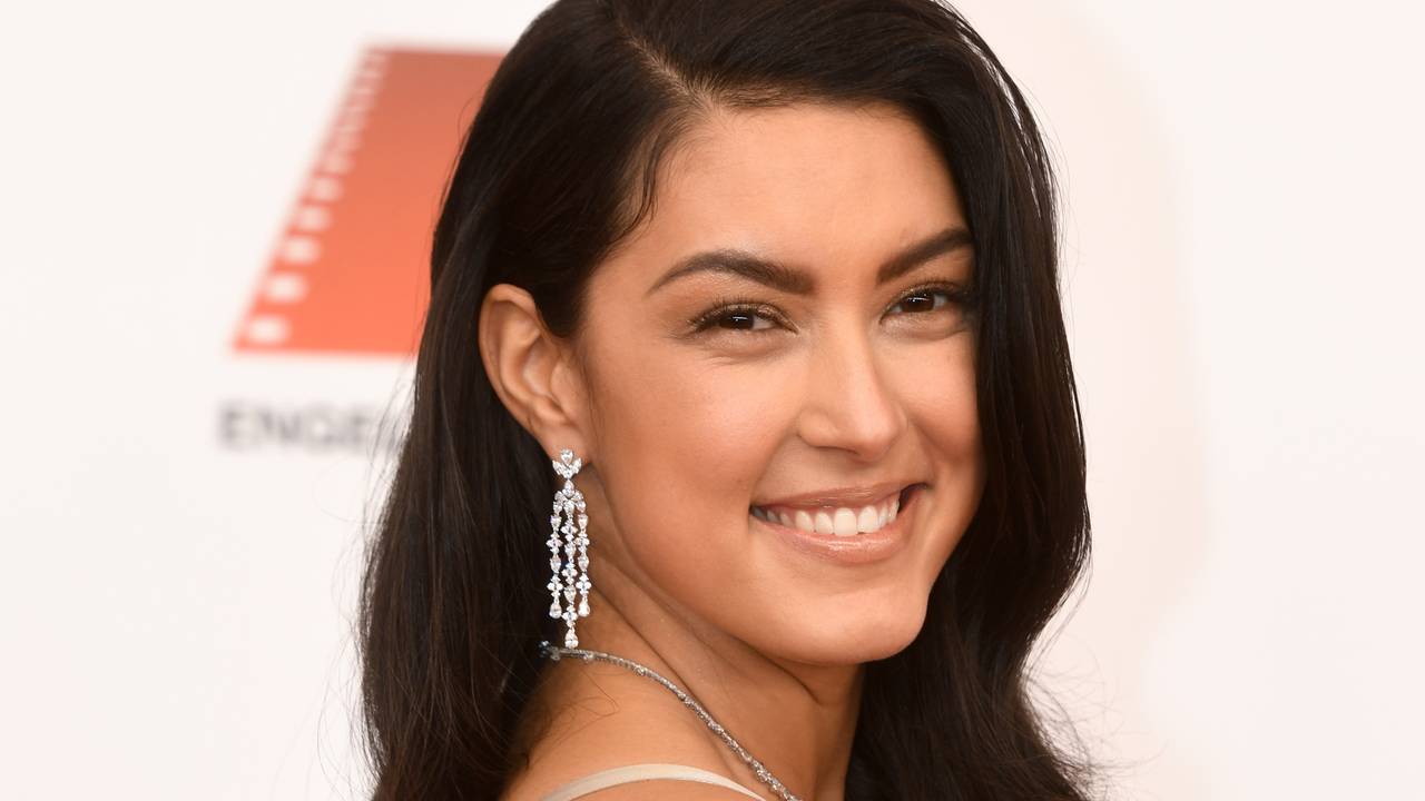 Rebecca Mir, Model, posiert beim 47. Deutschen Filmball ins Hotel Bayerischer Hof mit offenen Haaren in einem beigefarbenen Kleid.