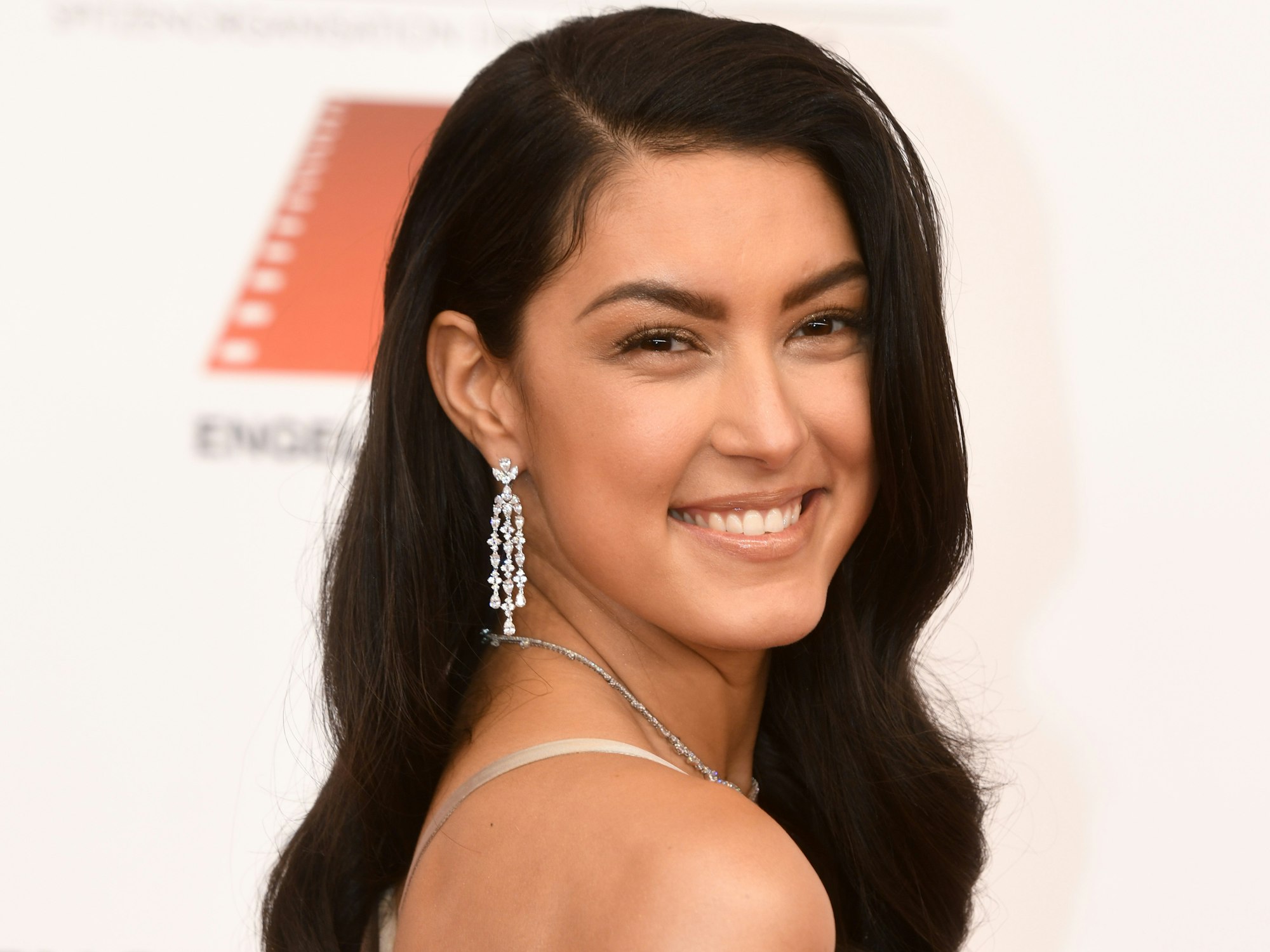 Rebecca Mir, Model, posiert beim 47. Deutschen Filmball ins Hotel Bayerischer Hof mit offenen Haaren in einem beigefarbenen Kleid.