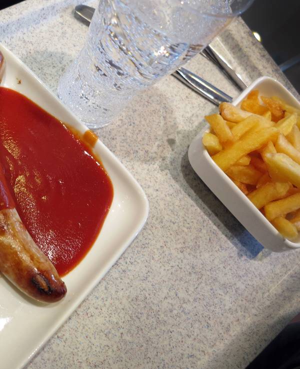 Ein Tablett mit einer Currywurst mit Pommes Frites steht in einer Kantine in Düsseldorf.