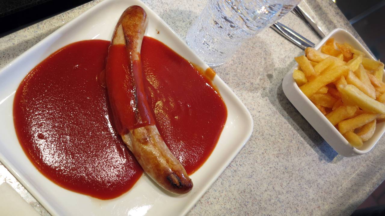 Ein Tablett mit einer Currywurst mit Pommes Frites steht in einer Kantine in Düsseldorf.