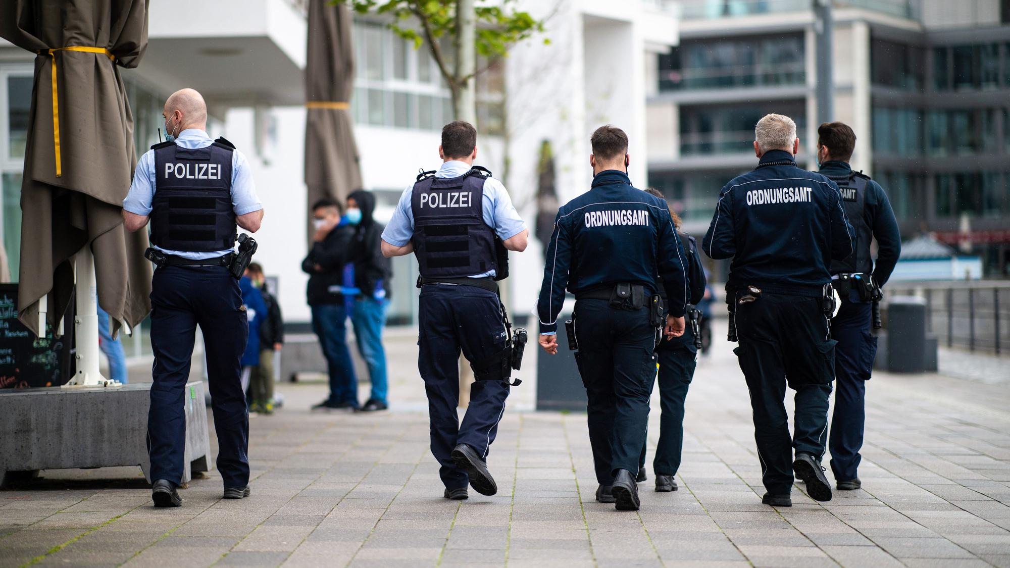 Mitarbeiter des Ordnungsamtes und Polizisten gehen durch Dortmund.