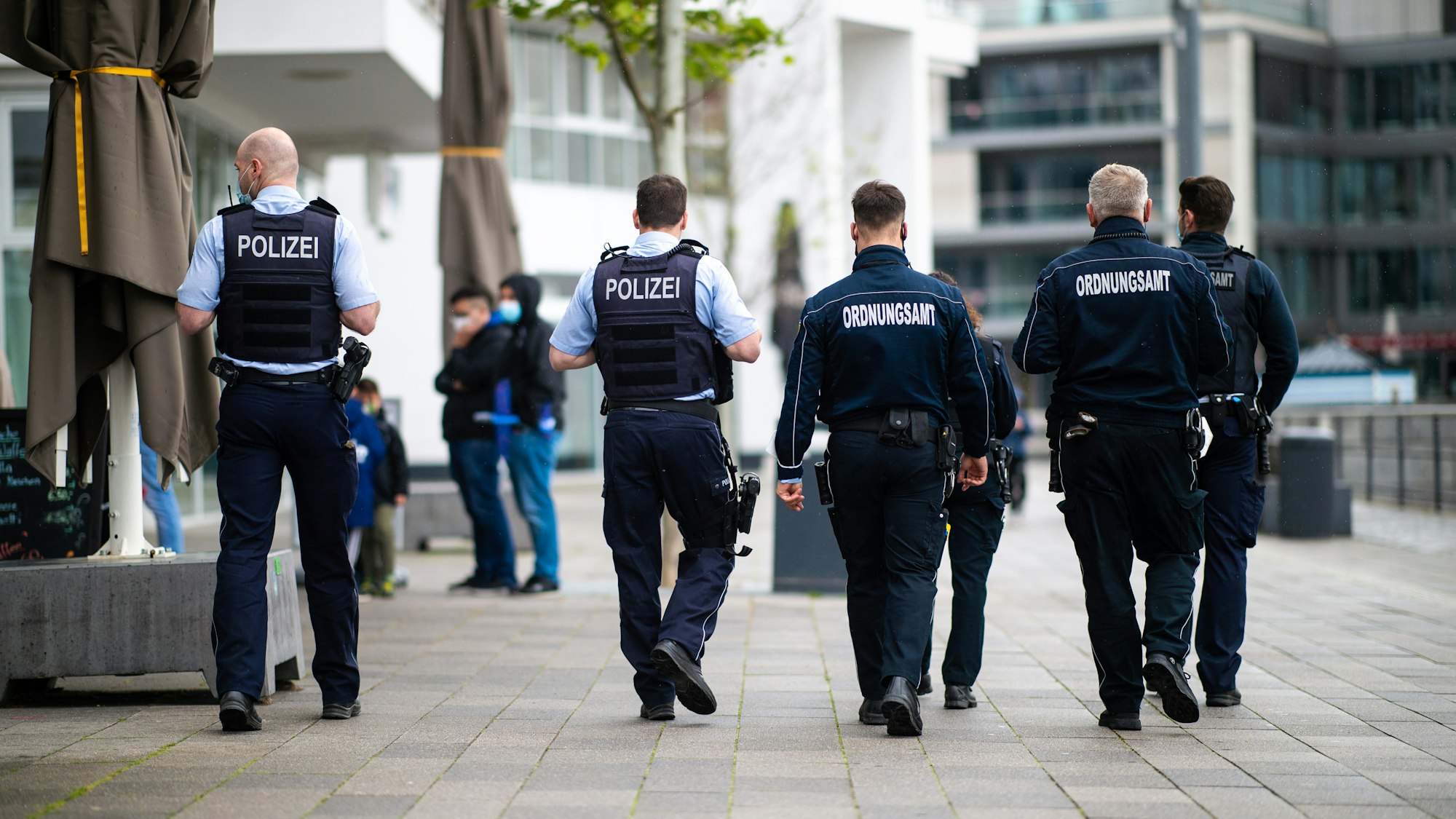 Mitarbeiter des Ordnungsamtes und Polizisten gehen durch Dortmund.