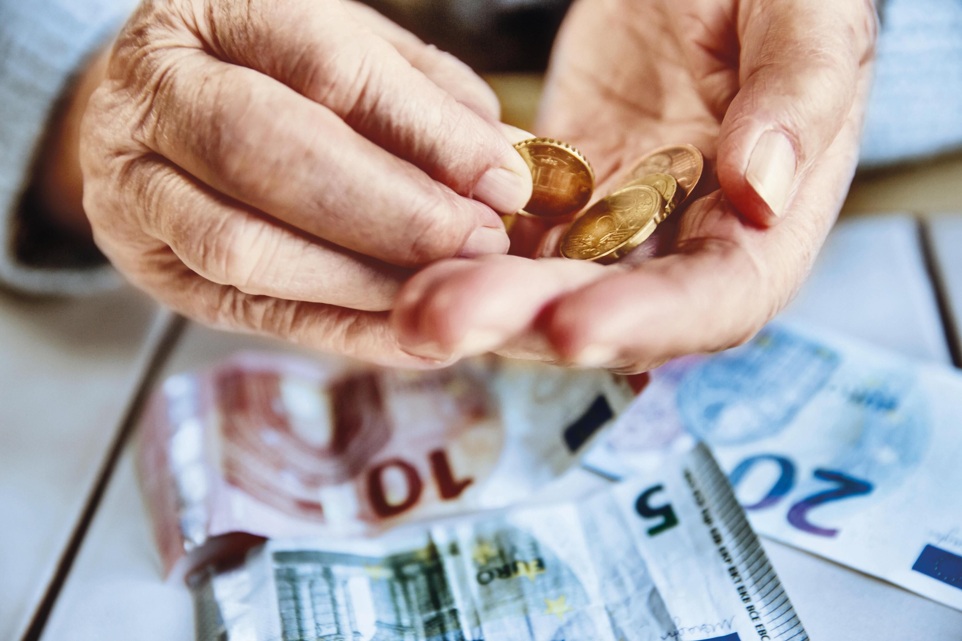 Ältere Frau zählt Bargeld in ihren Händen.