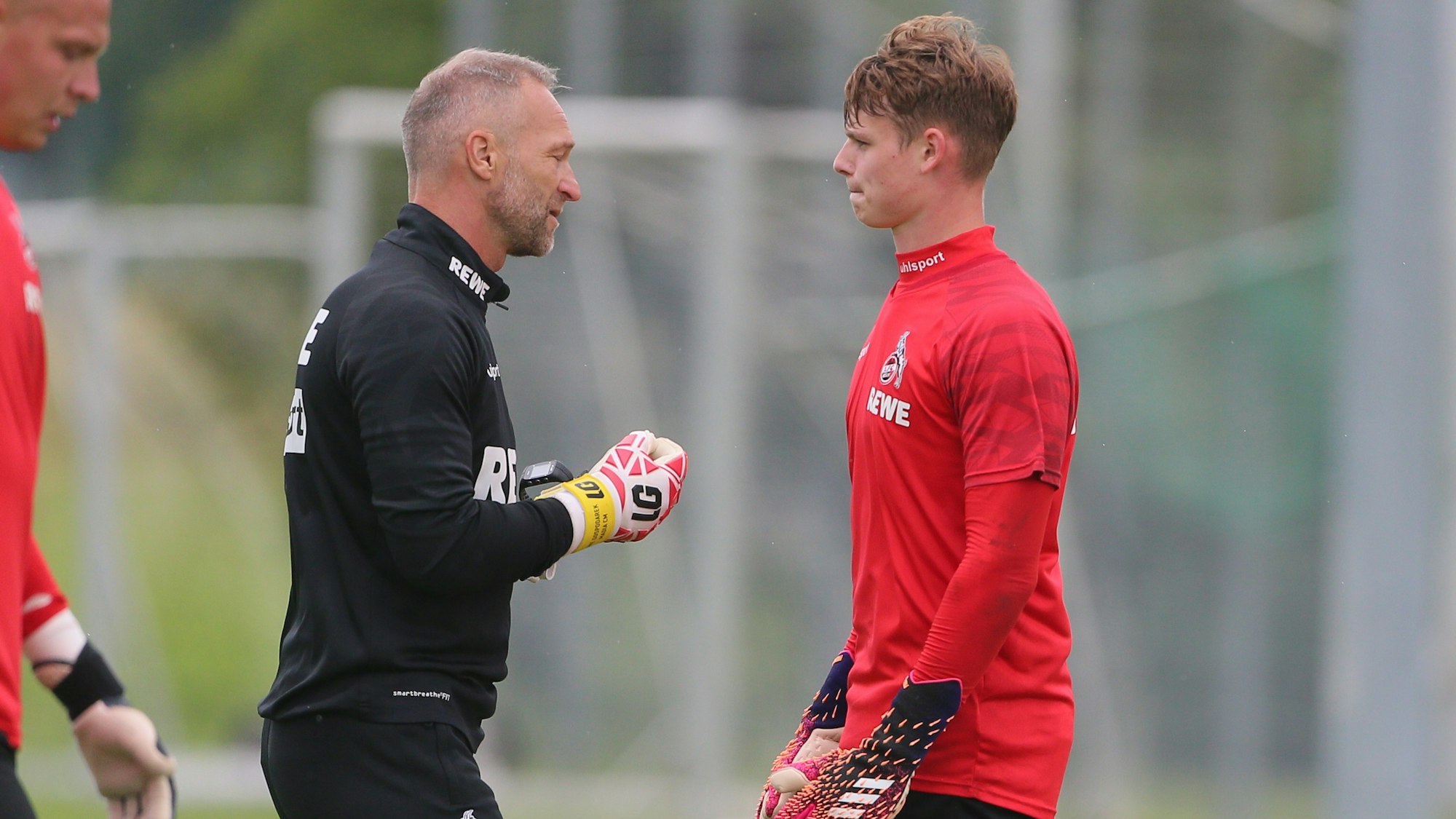 Jonas Urbig spricht mit FC-Torwarttrainer Uwe Gospodarek.