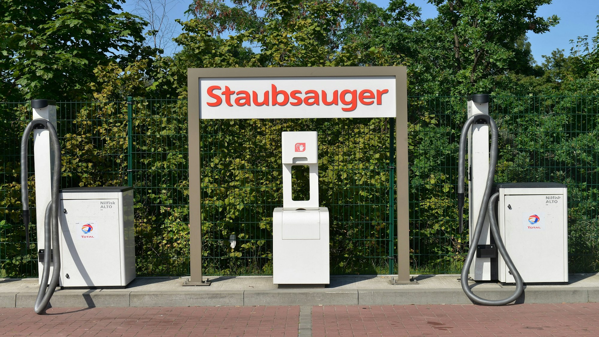 Ein stationärer Staubsauger an einer Tankstelle.