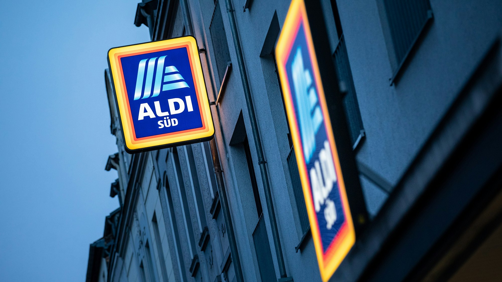 Die Leuchtreklame von Aldi Süd leuchtet am Abend über einer Filiale auf der Sülzburgstraße.