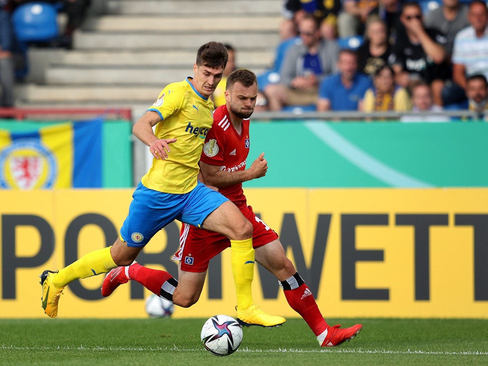 Im Spiel der ersten Runde des DFB-Pokals spielt Eintracht Braunschweigs Danilo Wiebe gegen Manuel Wintzheimer vom Hamburger SV den Ball.