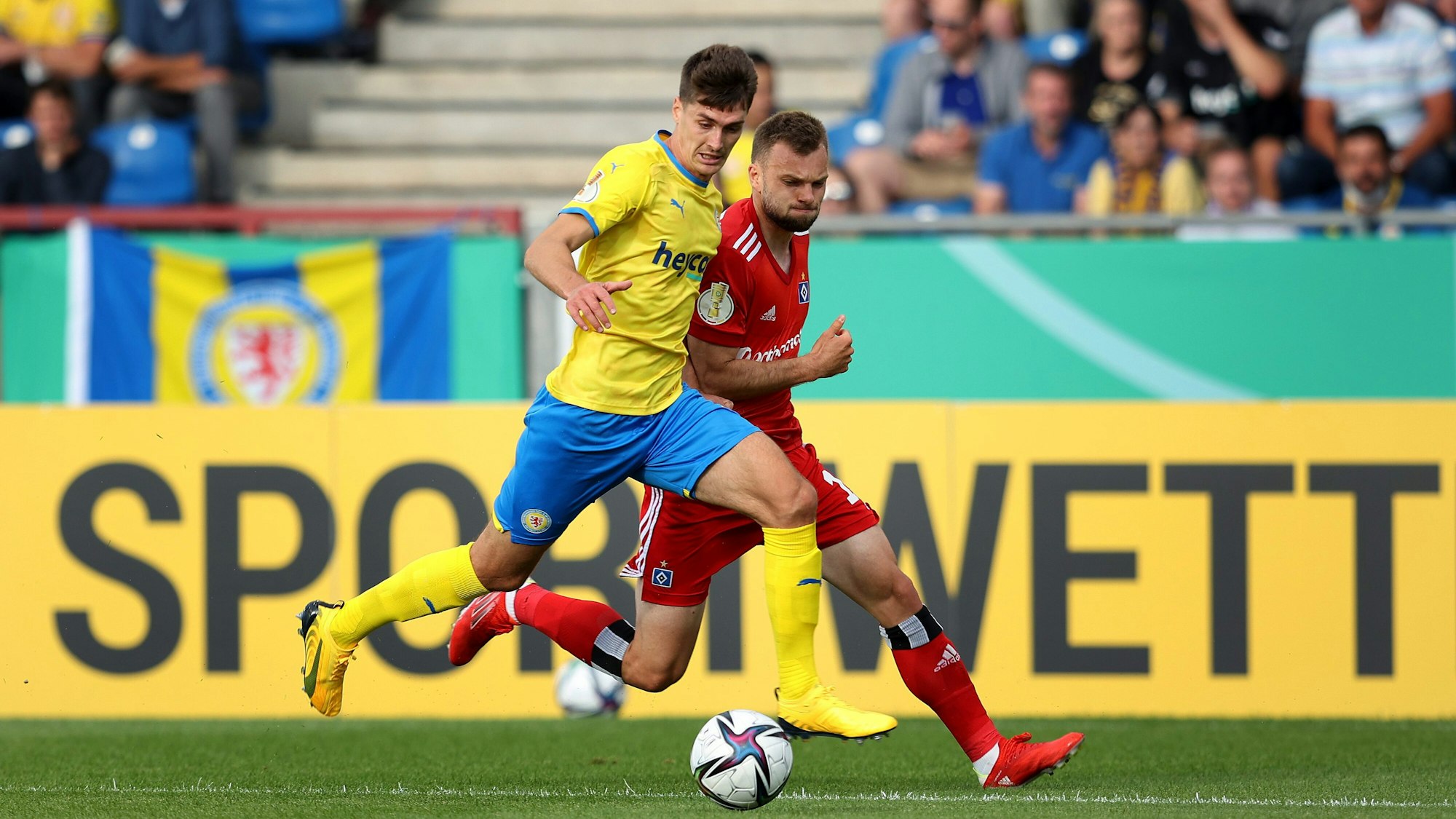 Im Spiel der ersten Runde des DFB-Pokals spielt Eintracht Braunschweigs Danilo Wiebe gegen Manuel Wintzheimer vom Hamburger SV den Ball.