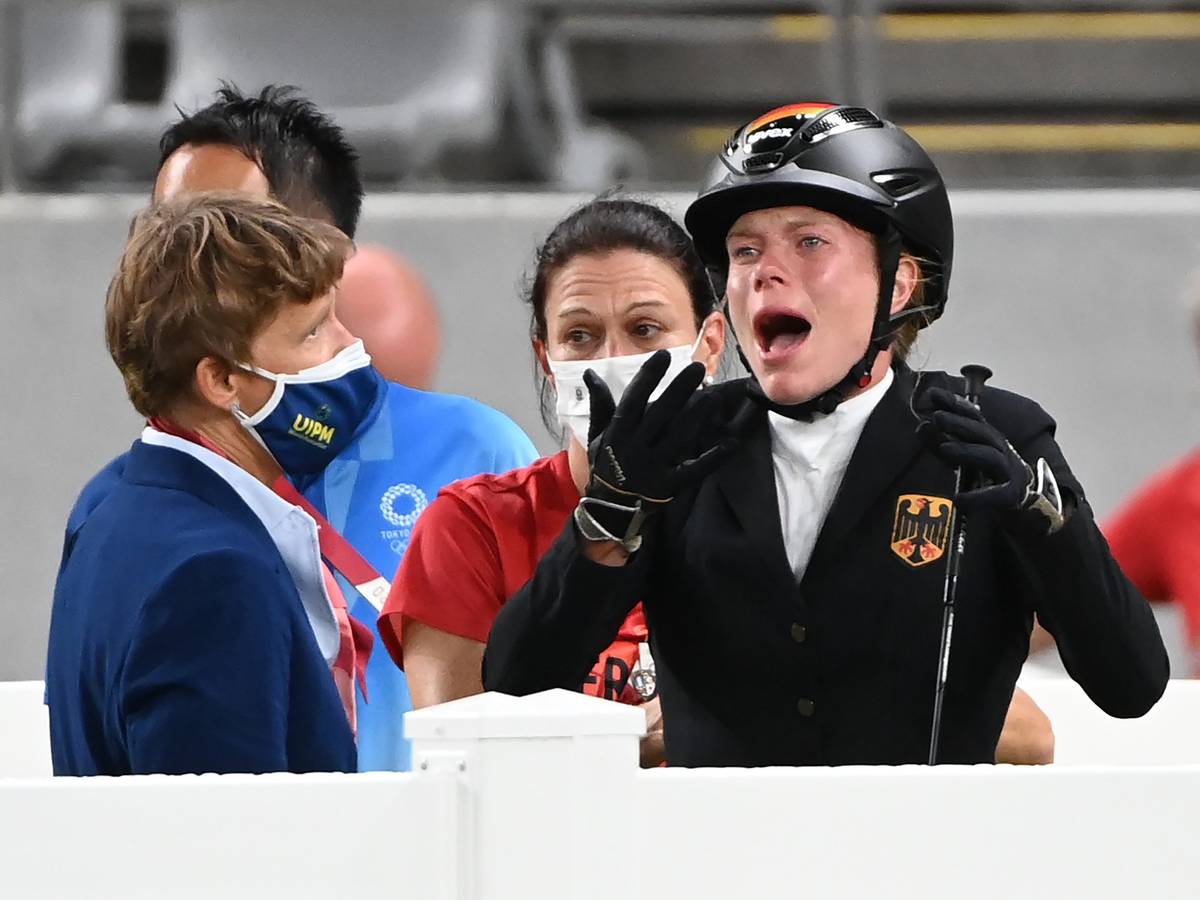 Annika Schleu (r) aus Deutschland weint bei Olympia, weil ihr Pferd mehrmals den Sprung verweigerte.