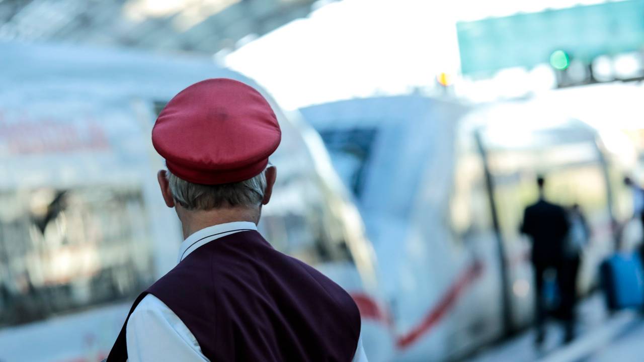 Ein Schaffner gibt ein Abfahrtszeichen für einen ICE auf dem Bahnsteig im Berliner Hauptbahnhof.