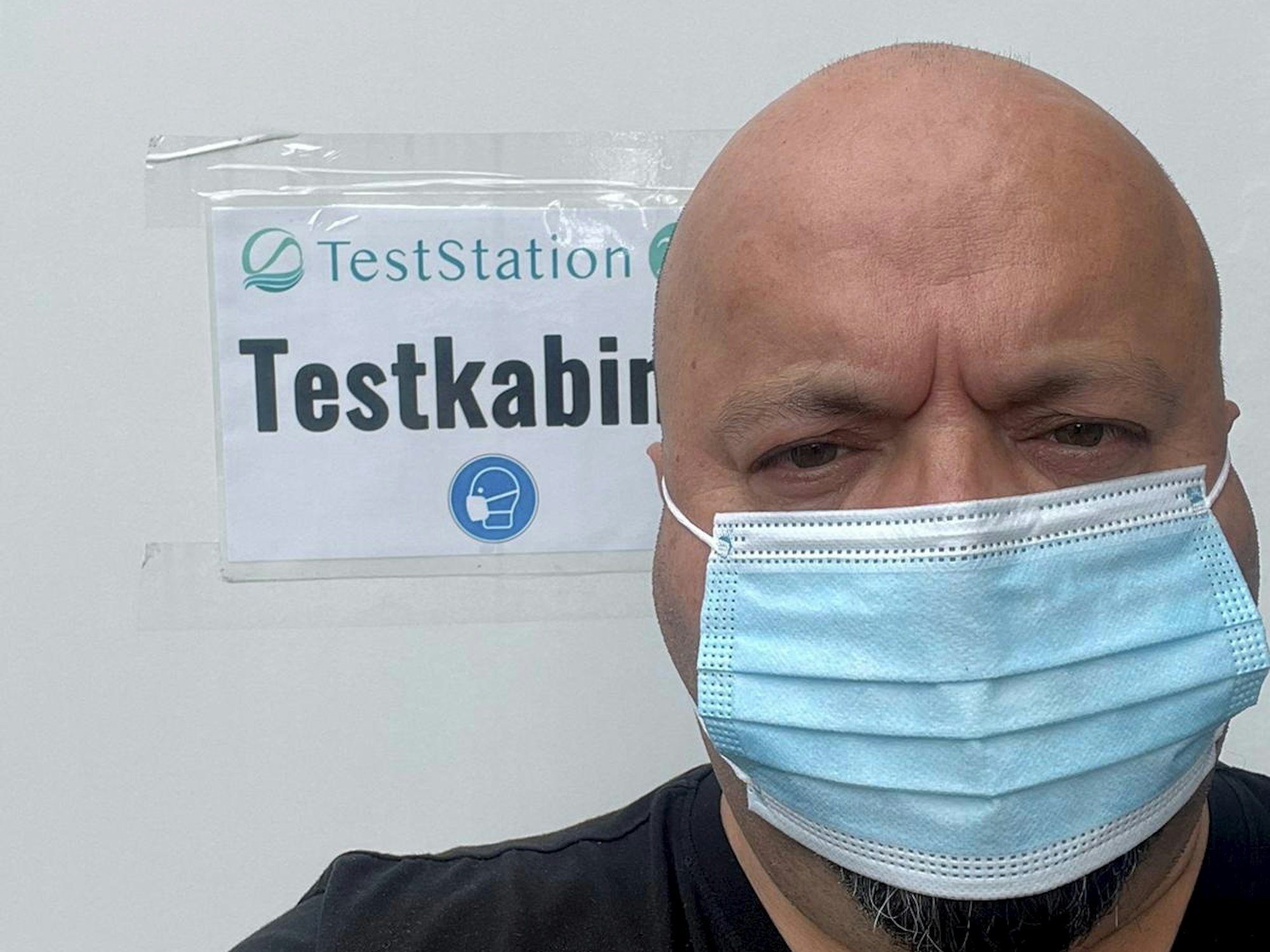 Coronateststationsbetreiber Yener Kisla steht mit Maske in der Testkabine in Ehrenfeld