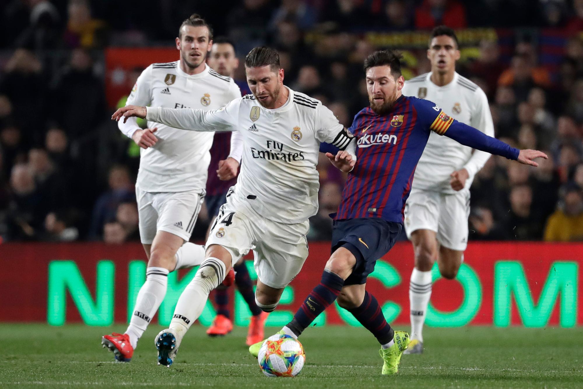 Real Madrids Sergio Ramos (M) und Lionel Messi (2.v.r.) vom FC Barcelona kämpfen um den Ball.