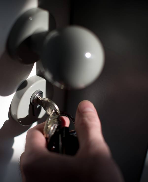 Ein Schlüssel steckt im Schloss einer Wohnungstür.