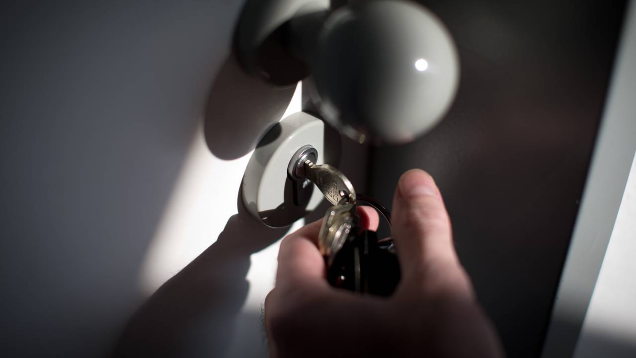 Ein Schlüssel steckt im Schloss einer Wohnungstür.