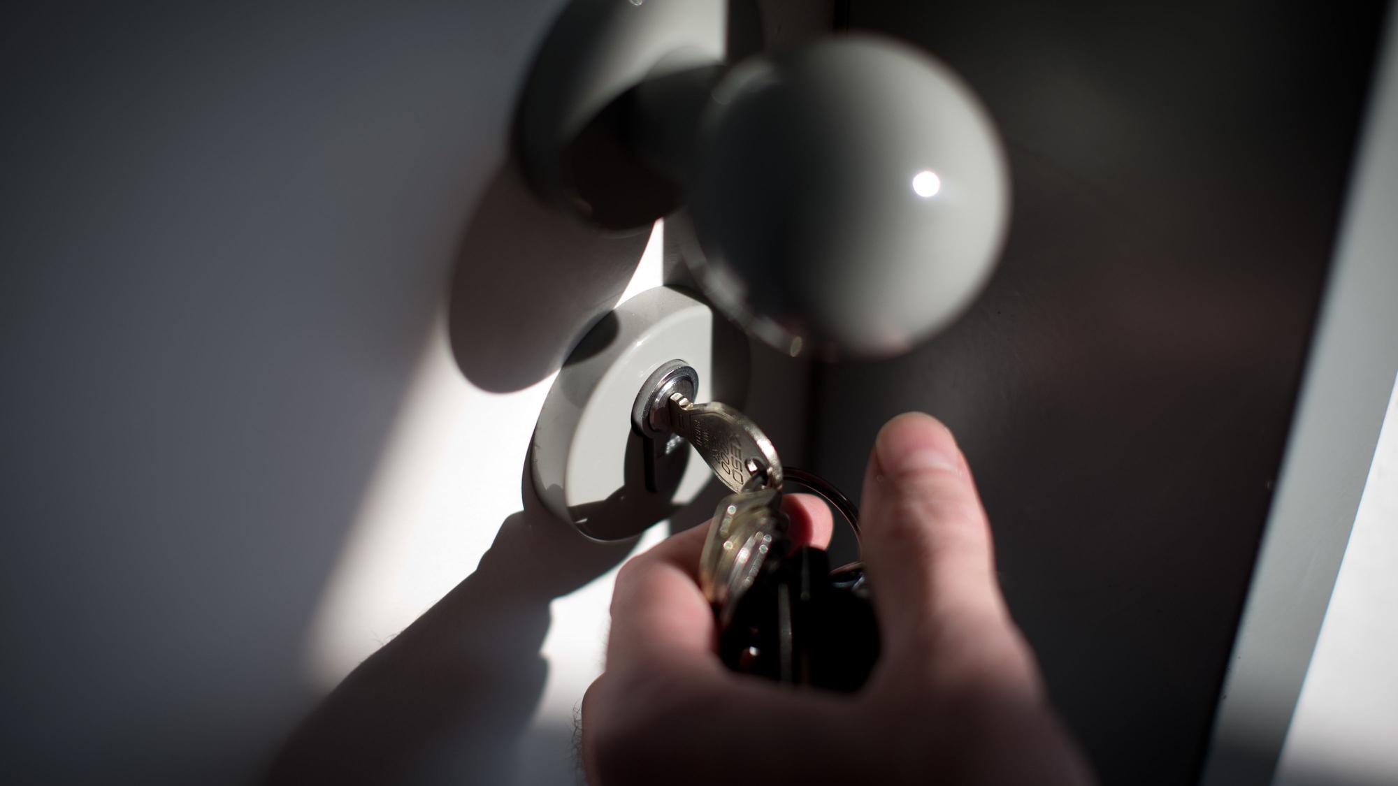 Ein Schlüssel steckt im Schloss einer Wohnungstür.