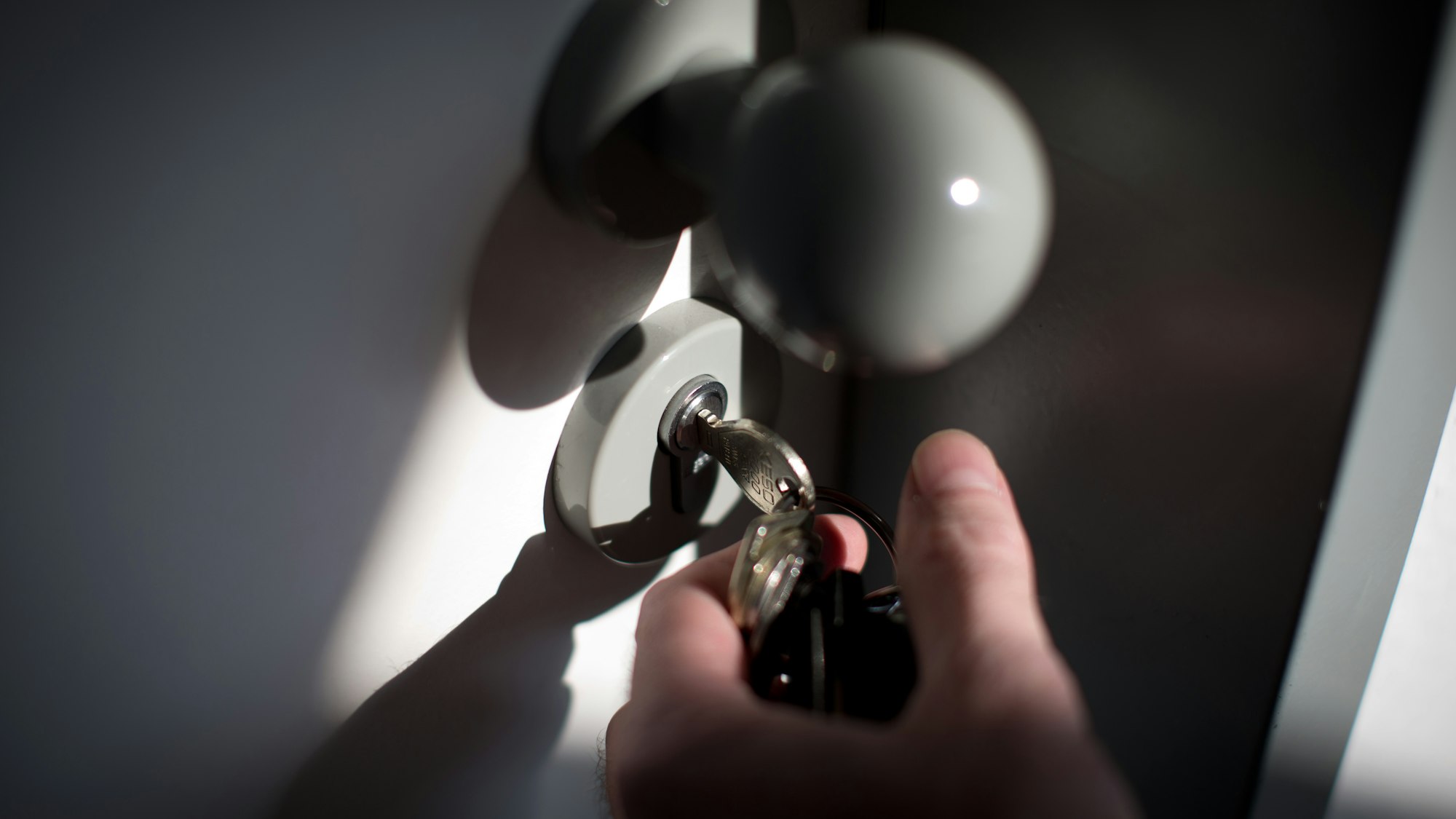 Ein Schlüssel steckt im Schloss einer Wohnungstür.