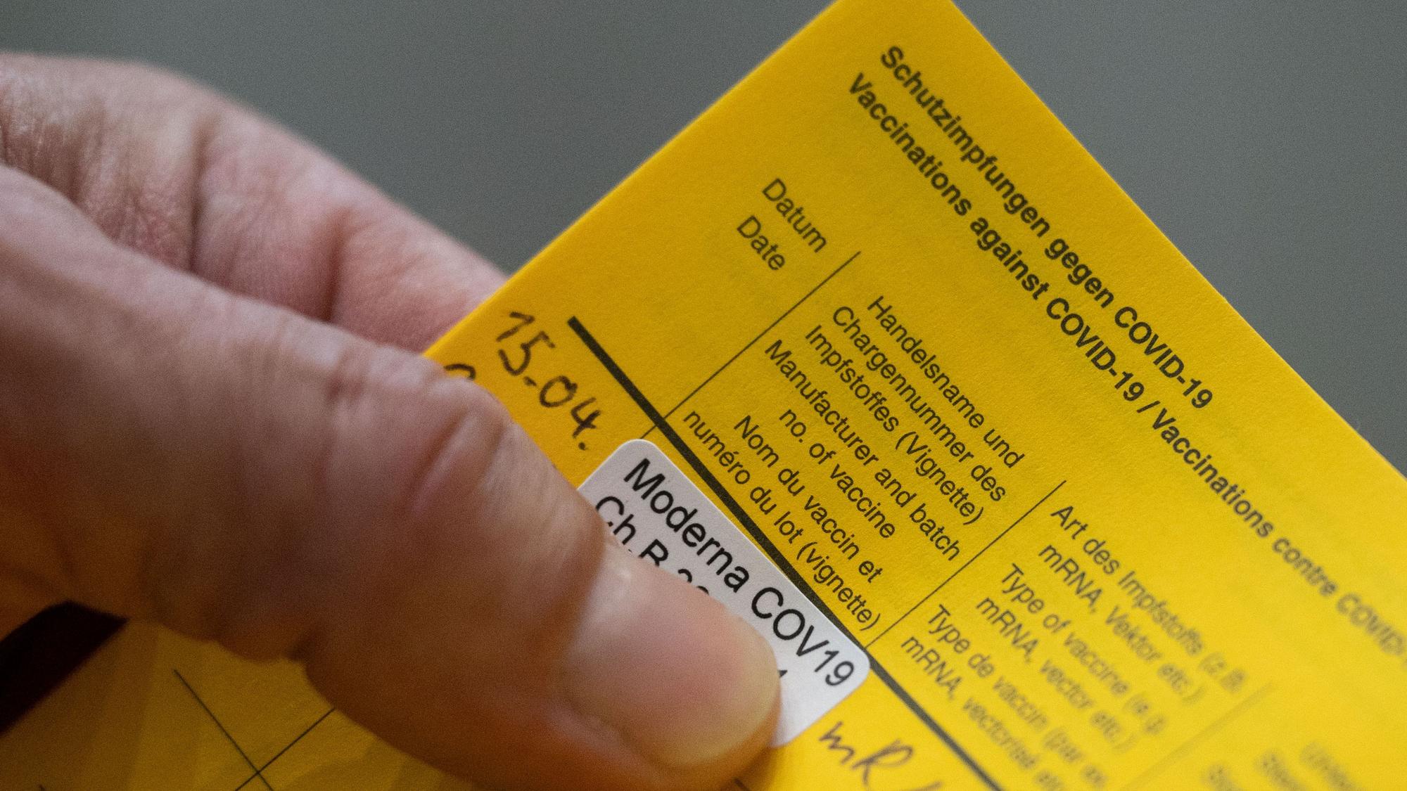 Ein Mann hält am 15. April 2021 in Stuttgart seinen Impfpass mit dem Nachweise seiner Moderna-Impfung gegen das Coronavirus in den Händen.