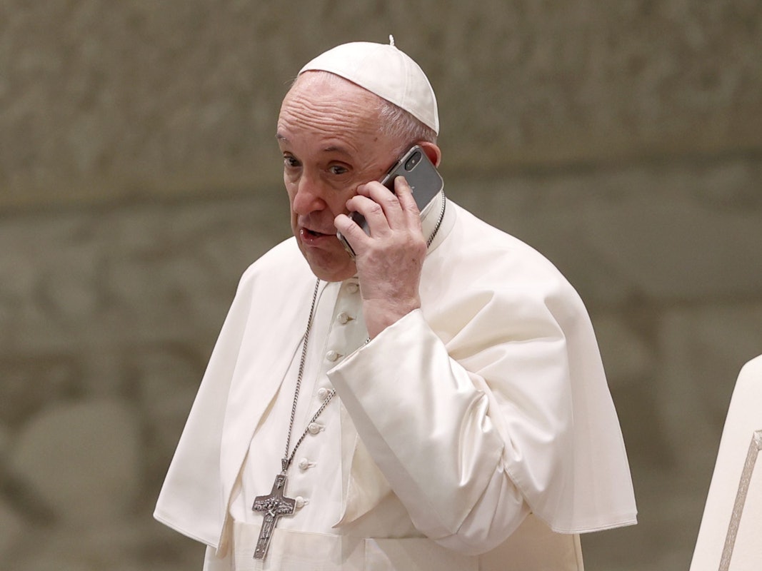 Papst Franziskus spricht am Ende seiner wöchentlichen Generalaudienz in der Halle Paul VI. in ein Telefon.