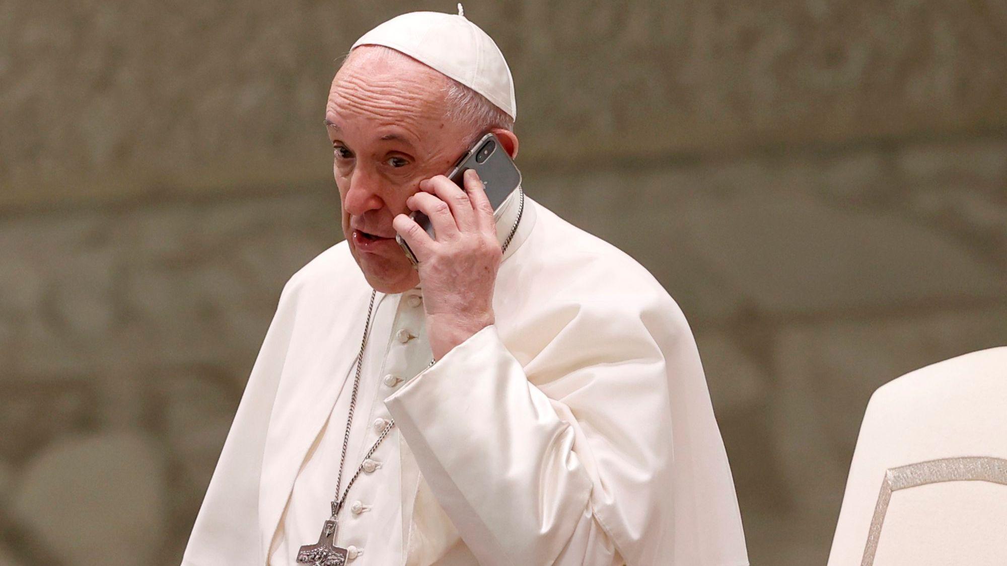 Papst Franziskus spricht am Ende seiner wöchentlichen Generalaudienz in der Halle Paul VI. in ein Telefon.