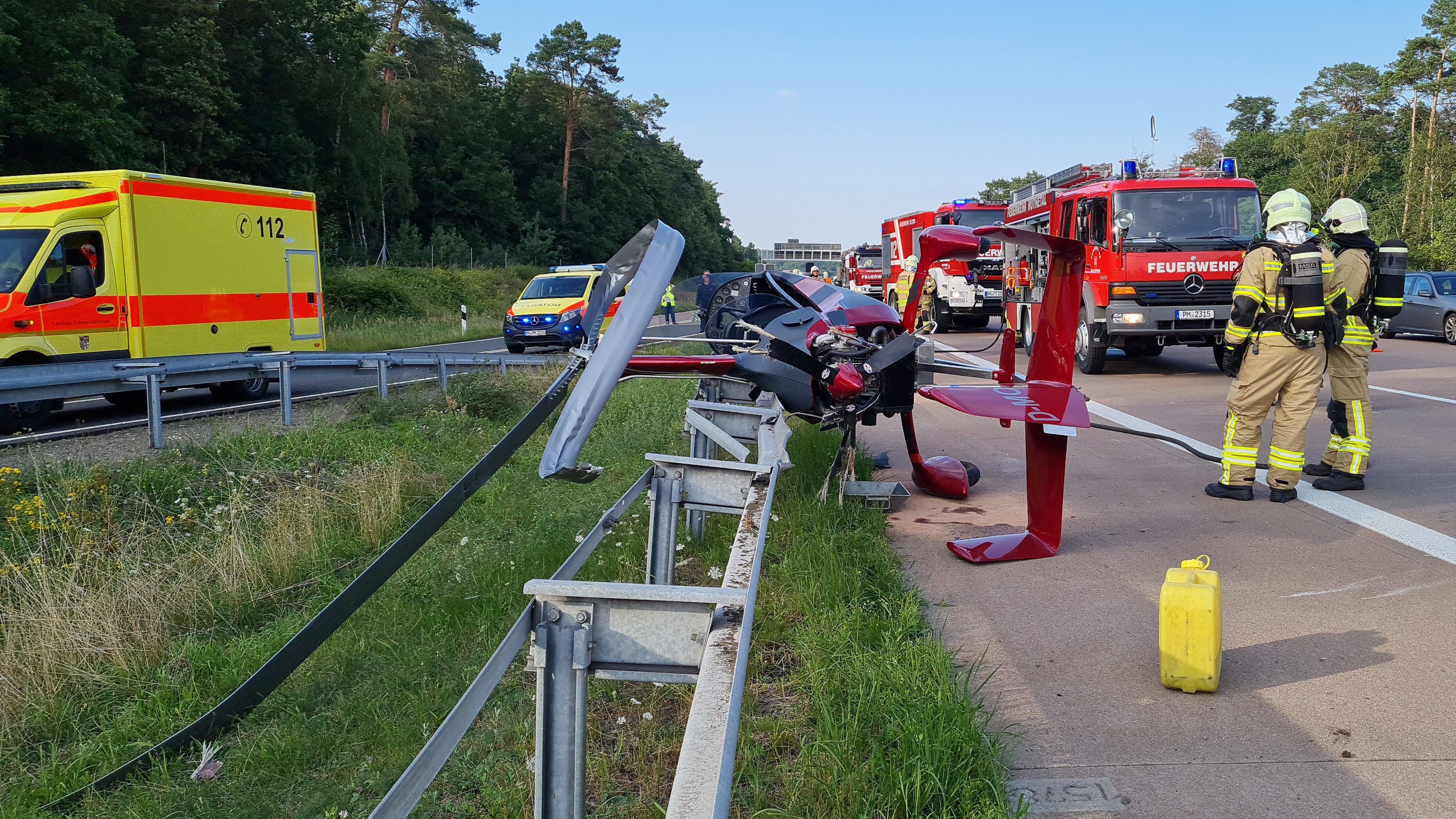 Brandenburg, Michendorf: Einsatzkräfte der Feuerwehr stehen an der Absturzstelle eines Tragschraubers am Autobahndreieck Nuthetal.