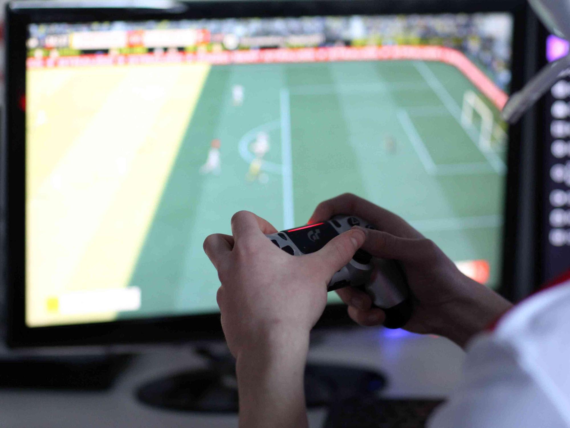 Ein Spieler spielt am Computer Fußball.