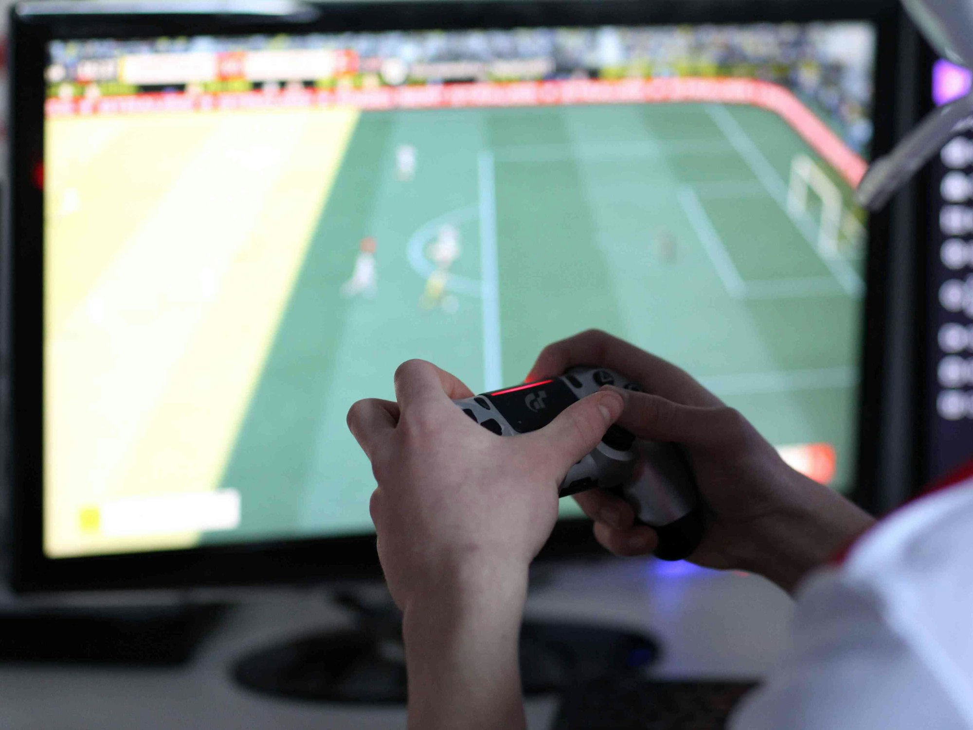 Ein Spieler spielt am Computer Fußball.