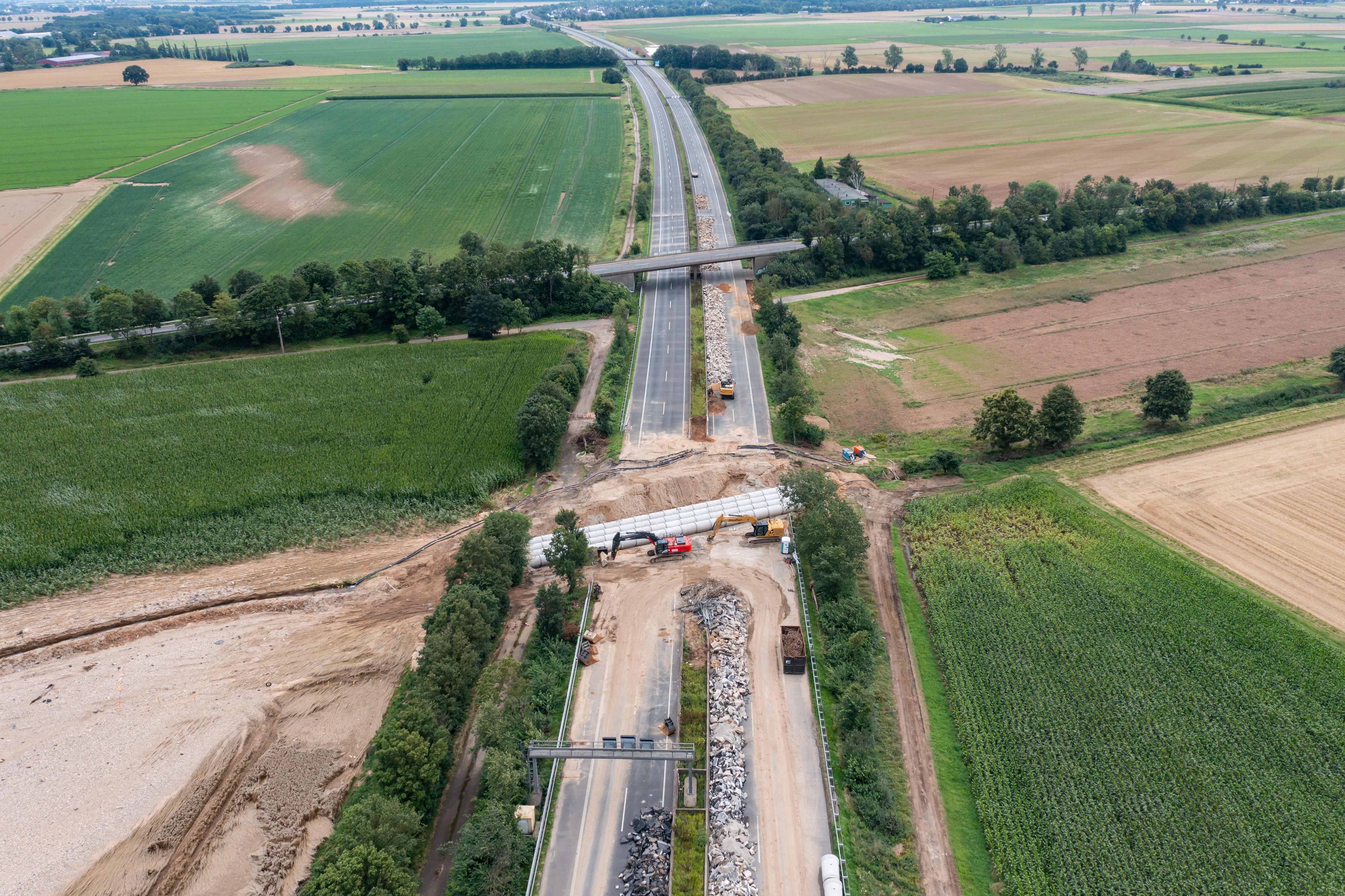 Rohre werden an der Stelle der A61 bei Swisttal-Ollheim verlegt, wo die Autobahn durch die Flutkatastrophe absackte und zerstört wurde. Die A61 ist bei Swisttal noch auf unbestimmte Zeit voll gesperrt.
