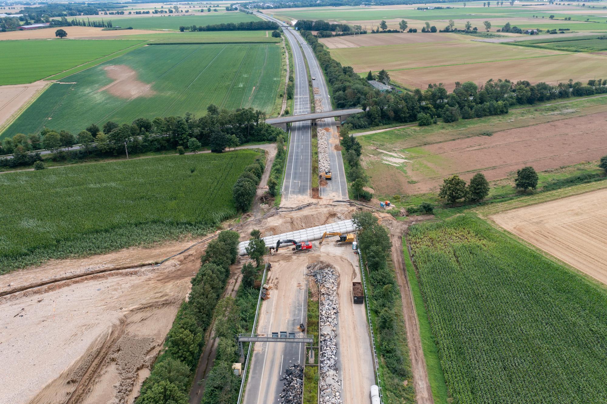 Rohre werden an der Stelle der A61 bei Swisttal-Ollheim verlegt, wo die Autobahn durch die Flutkatastrophe absackte und zerstört wurde. Die A61 ist bei Swisttal noch auf unbestimmte Zeit voll gesperrt.