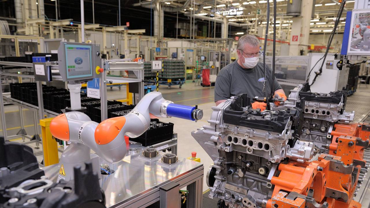 Ein Roboter arbeitet bei Ford mit einem Mitarbeiter zusammen an einem Motorblock.